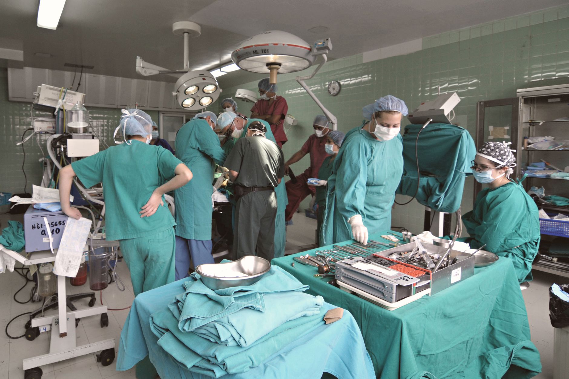 A surgical team performs an operation in a hospital operating room.