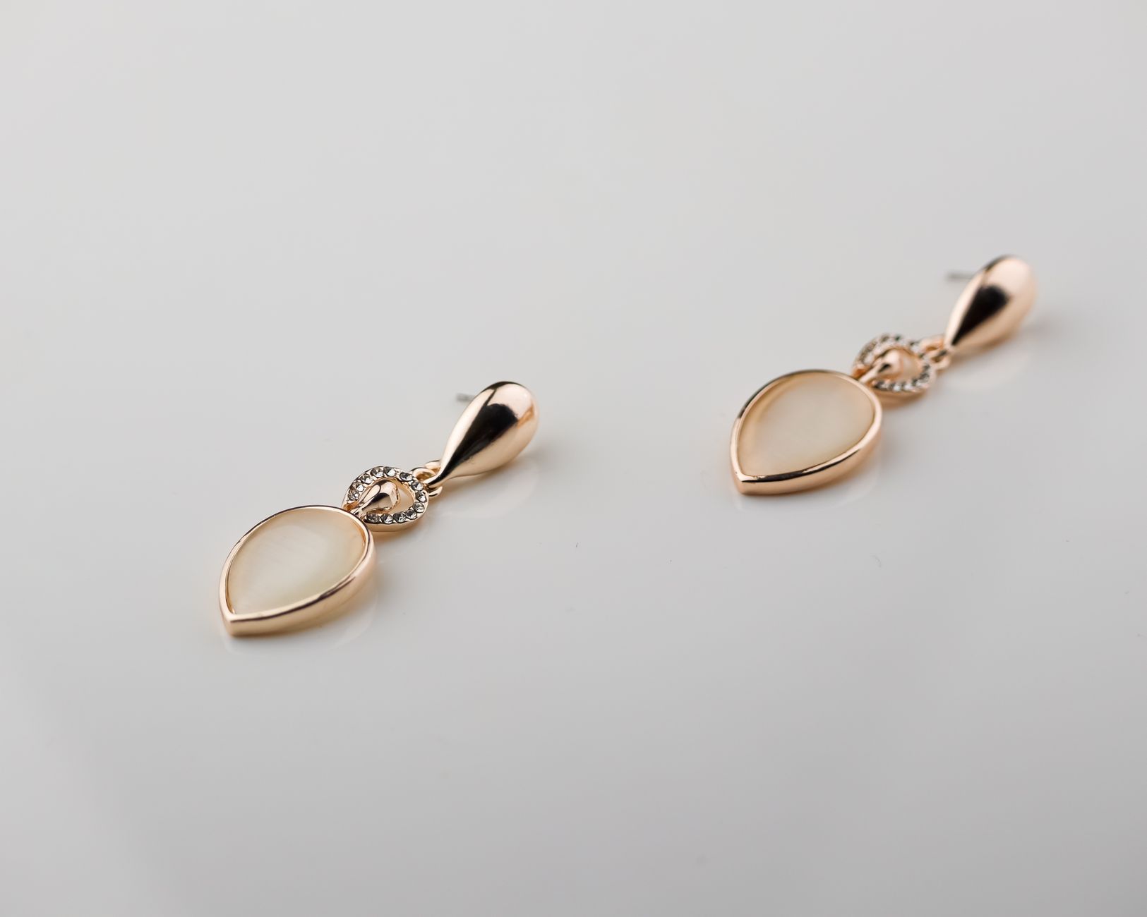 Stylish golden teardrop earrings with gemstone accents against a white background, perfect for fashion and jewelry lovers.