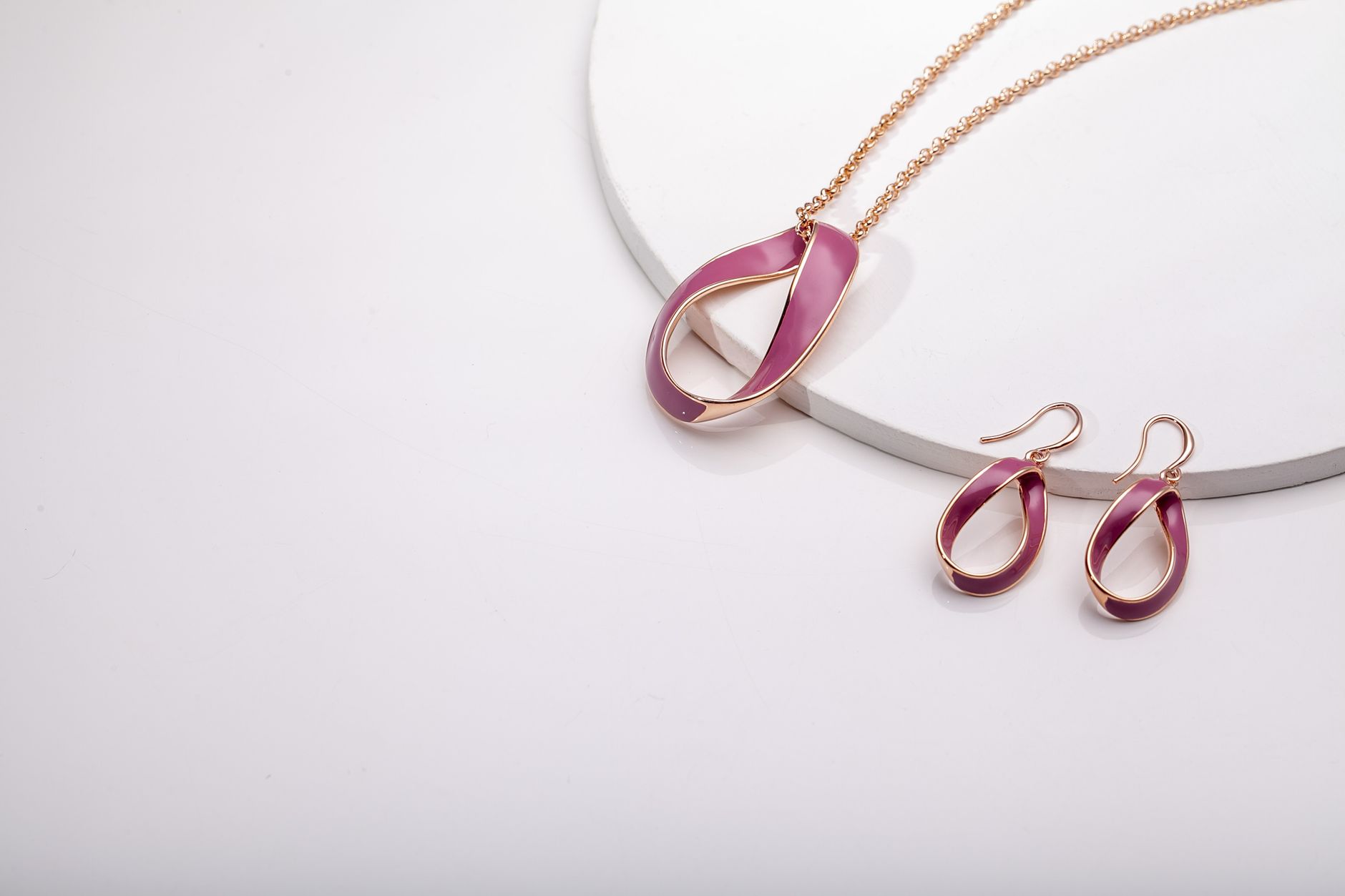 Stylish rose gold and pink jewelry set displayed on a white surface, ideal for fashion lovers.