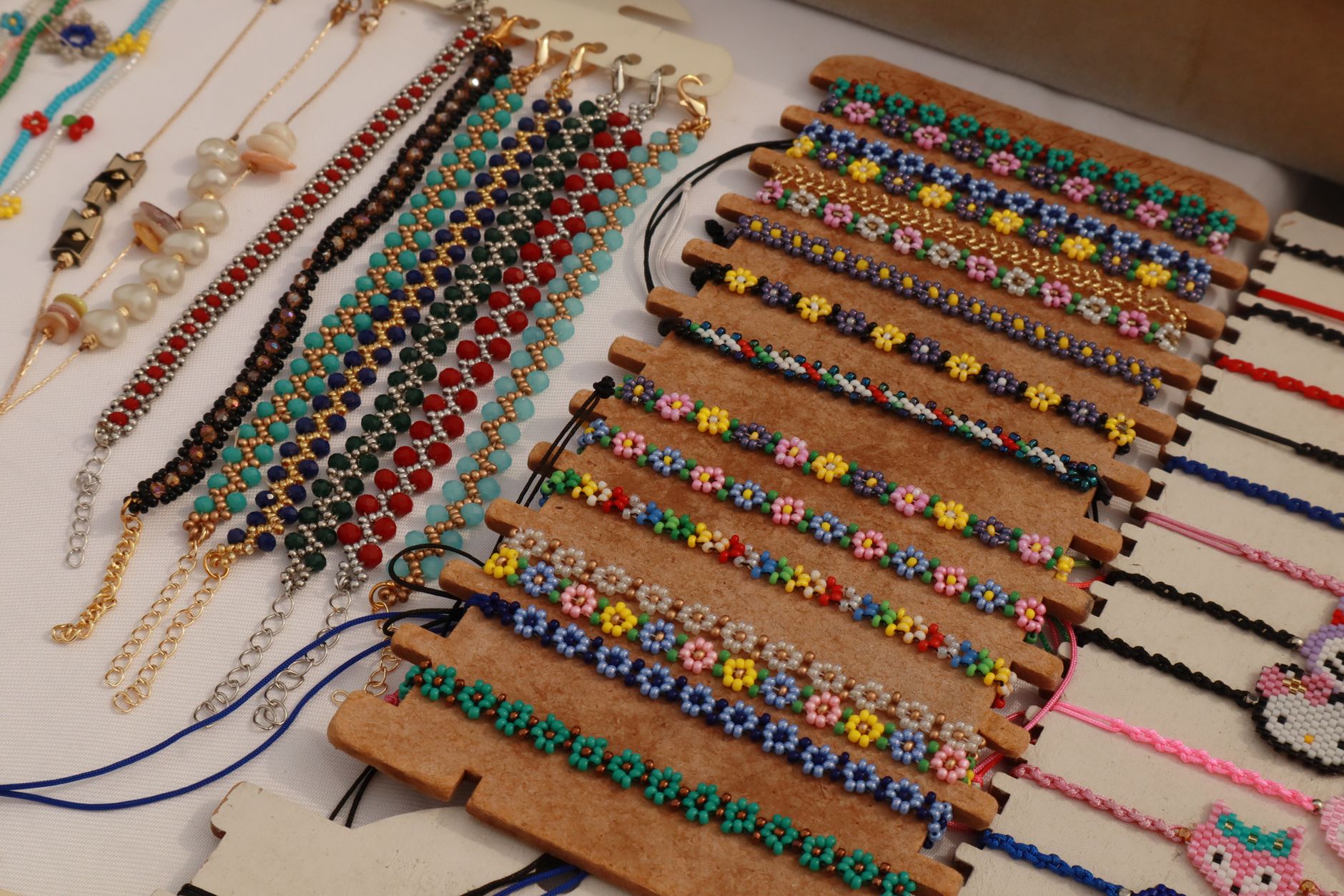 A variety of colorful handmade beaded bracelets on display at a market stall.