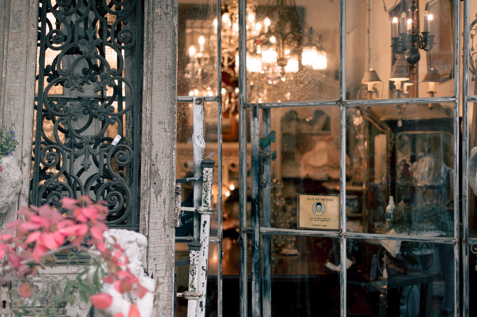 Elegant vintage shop entrance with glass doors and chandeliers visible inside, creating a retro atmosphere.