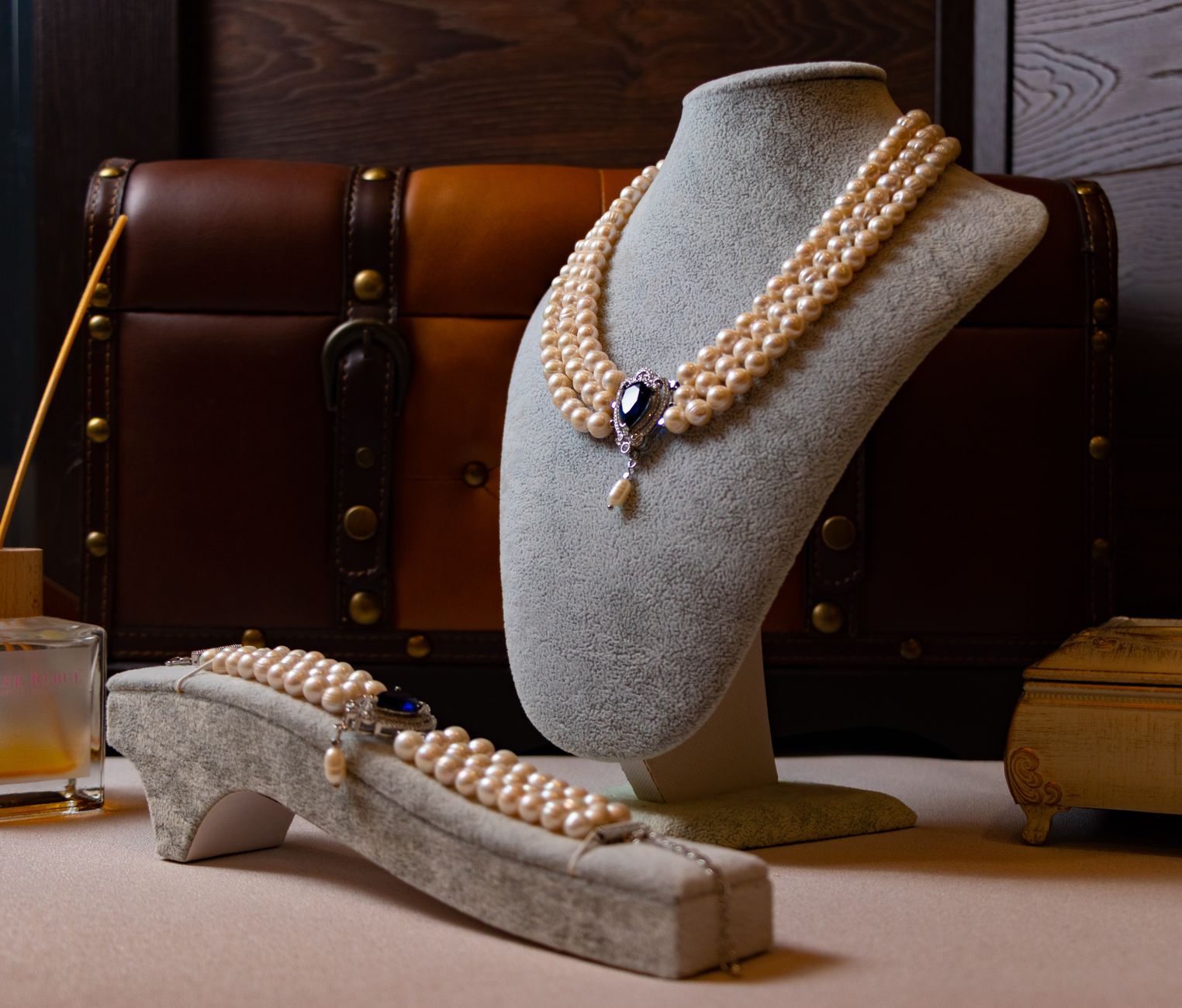 Elegant pearl necklace and bracelet set in a luxurious indoor setting with a classic style.