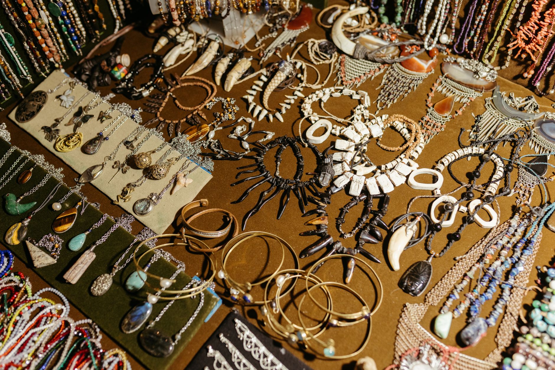 A vibrant display of handcrafted jewelry including necklaces, bracelets, and earrings at a market stall.