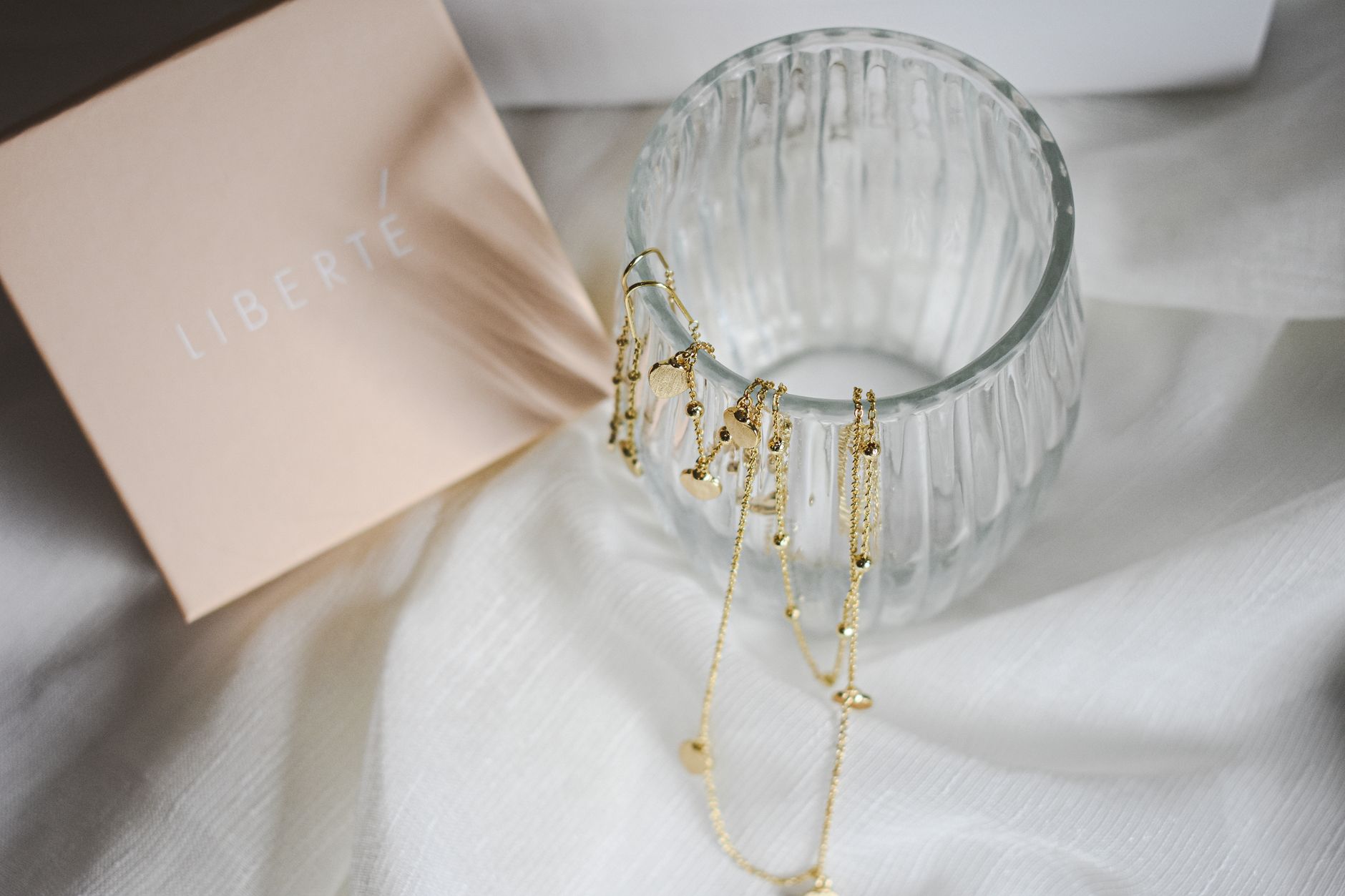 Elegant gold jewelry over a decorative glass, perfect for luxury branding.