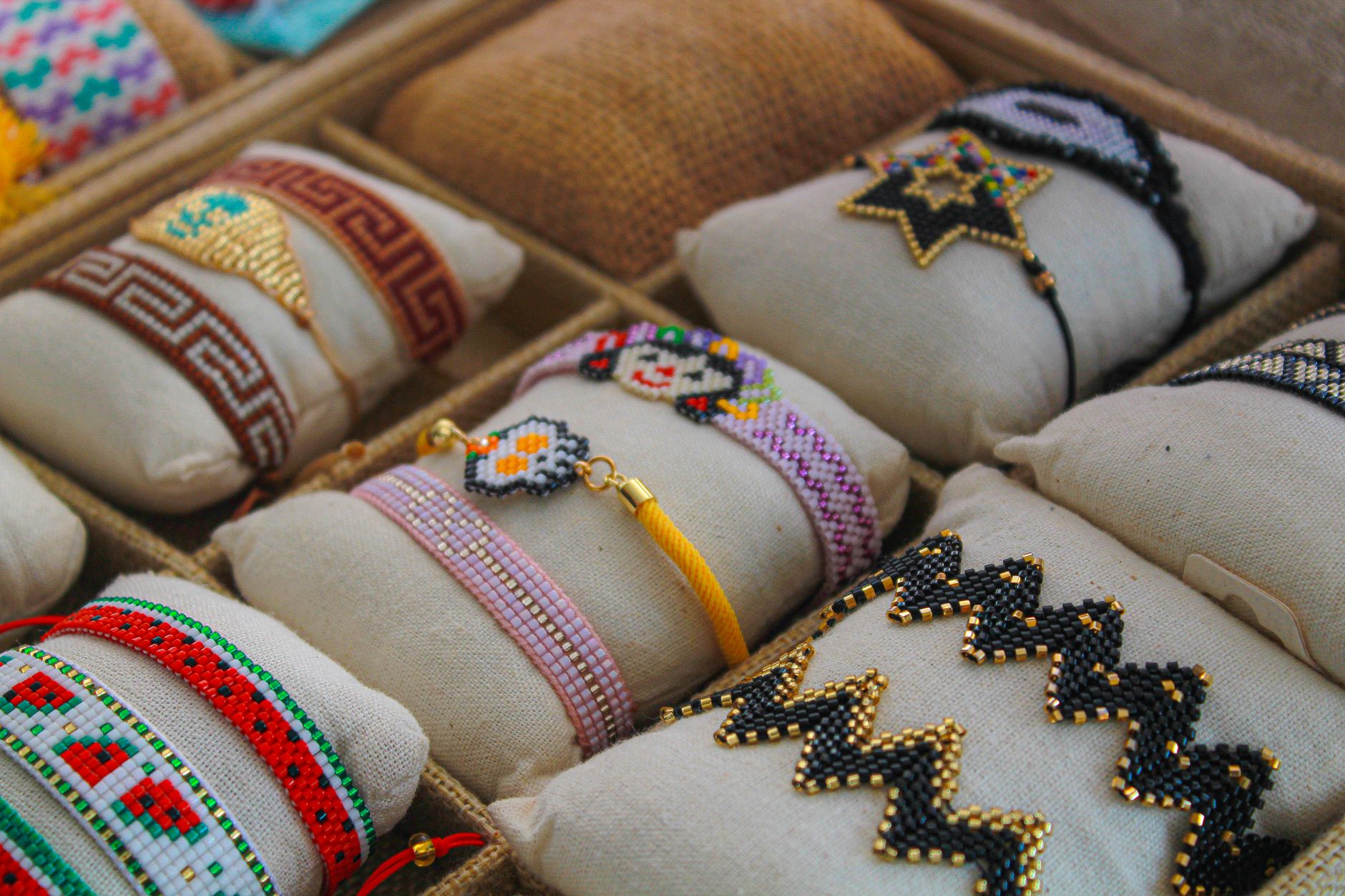 Close-up of vibrant handmade beaded bracelets in a market store display, showcasing intricate craftsmanship.