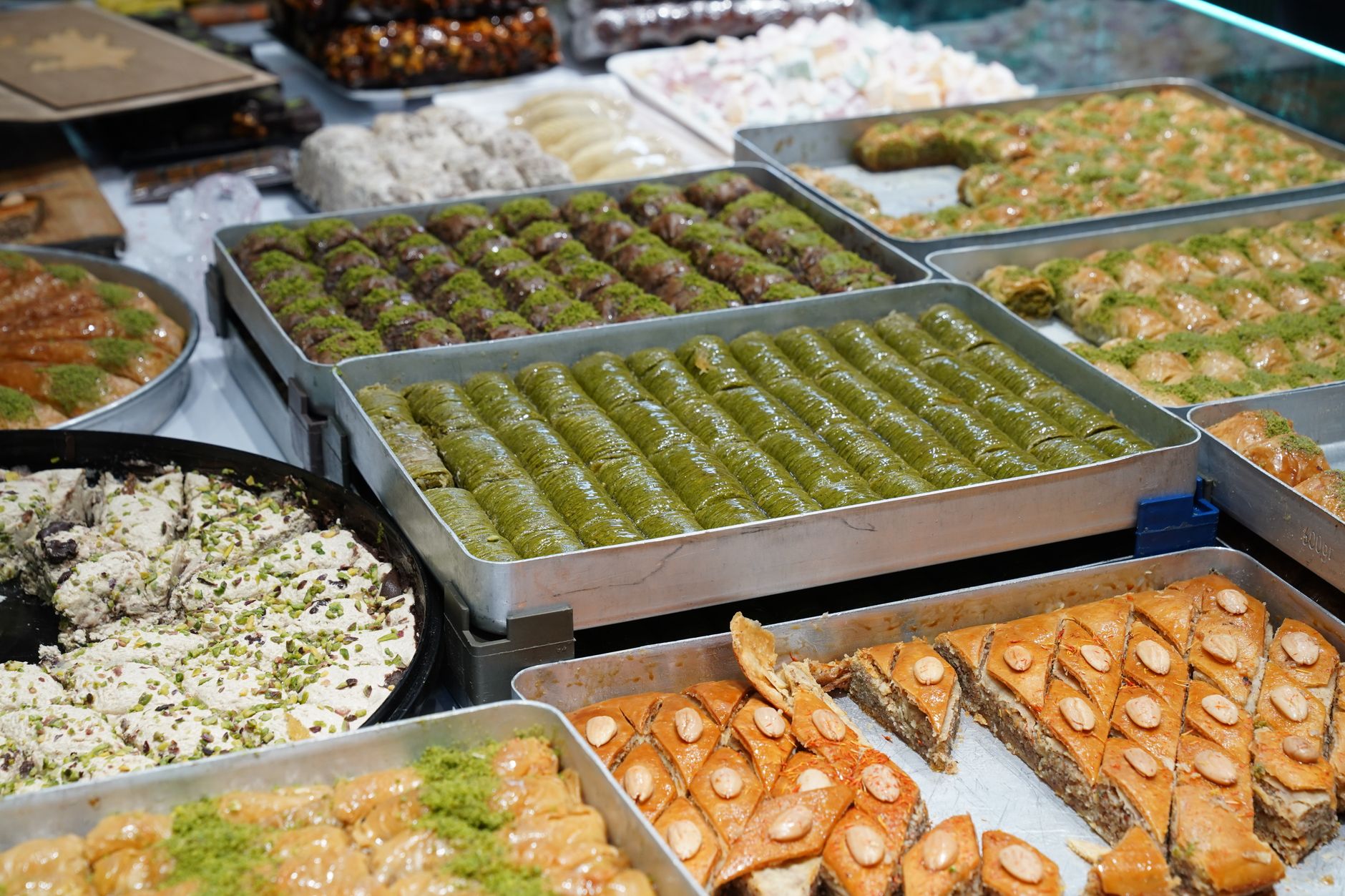 An array of freshly baked Turkish desserts including baklava and lokum, showcasing a delicious variety.