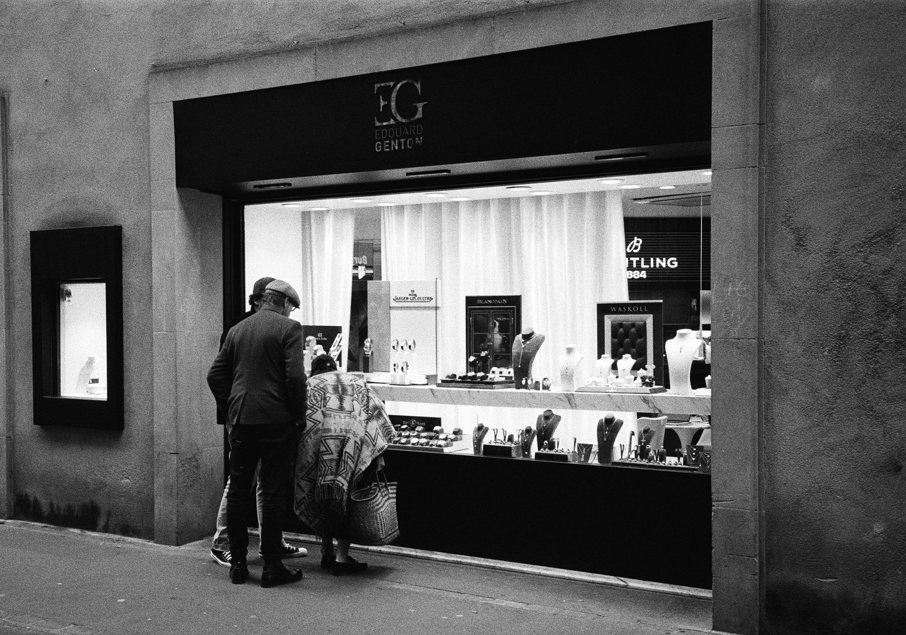 Stylish individuals browsing jewelry at Edouard Genton in Metz, France.