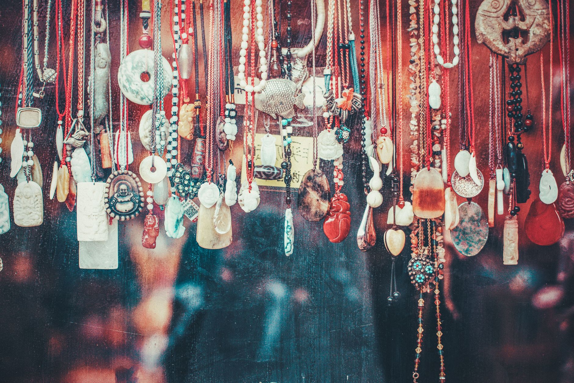 Vibrant collection of various pendants hanging in a Beijing market. A display of cultural and artistic jewelry.