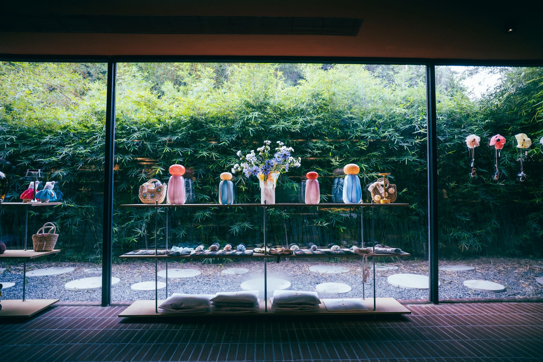 Beautiful glass art and decor showcased against a lush bamboo backdrop in a contemporary store.
