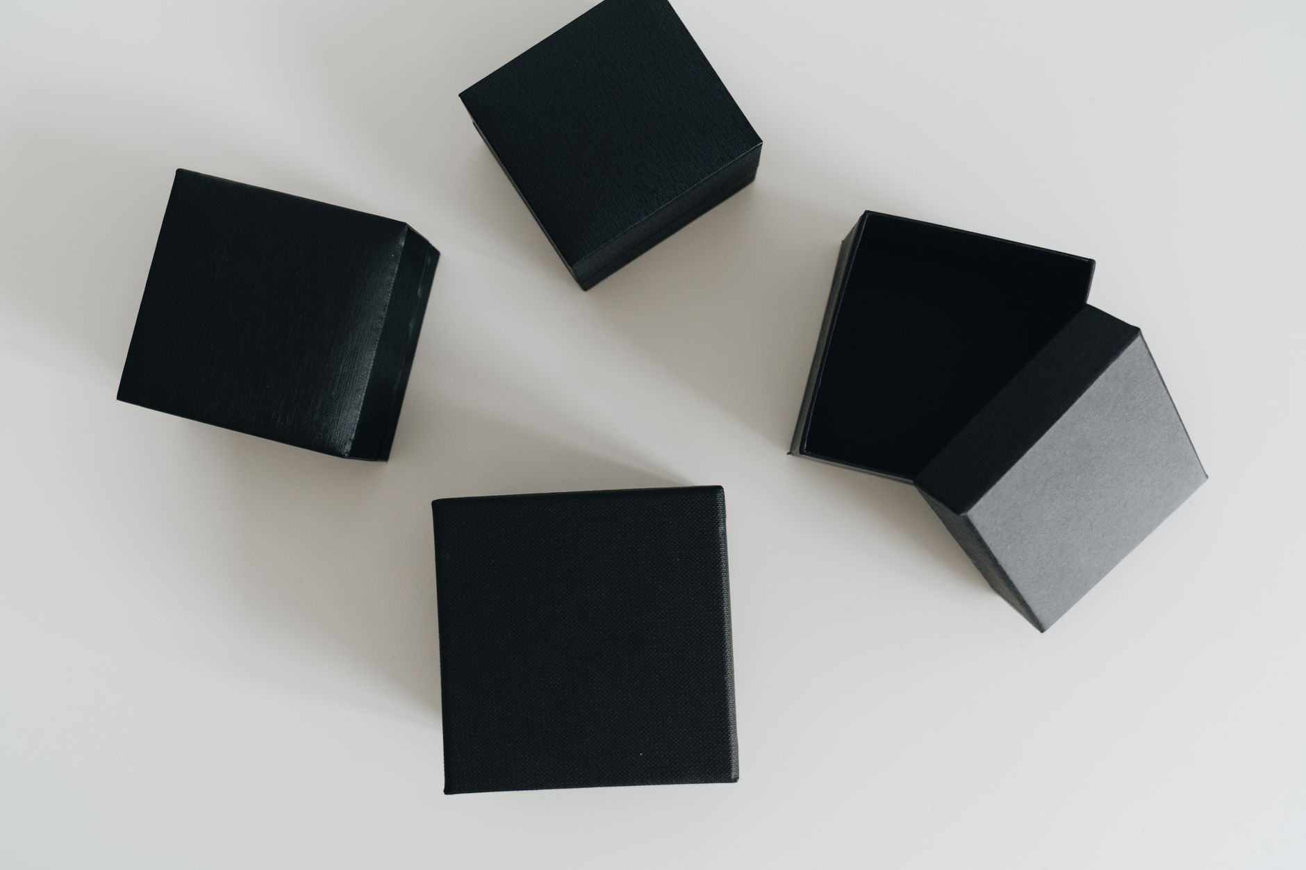 Aesthetic flat lay of black boxes open on a clean white surface.