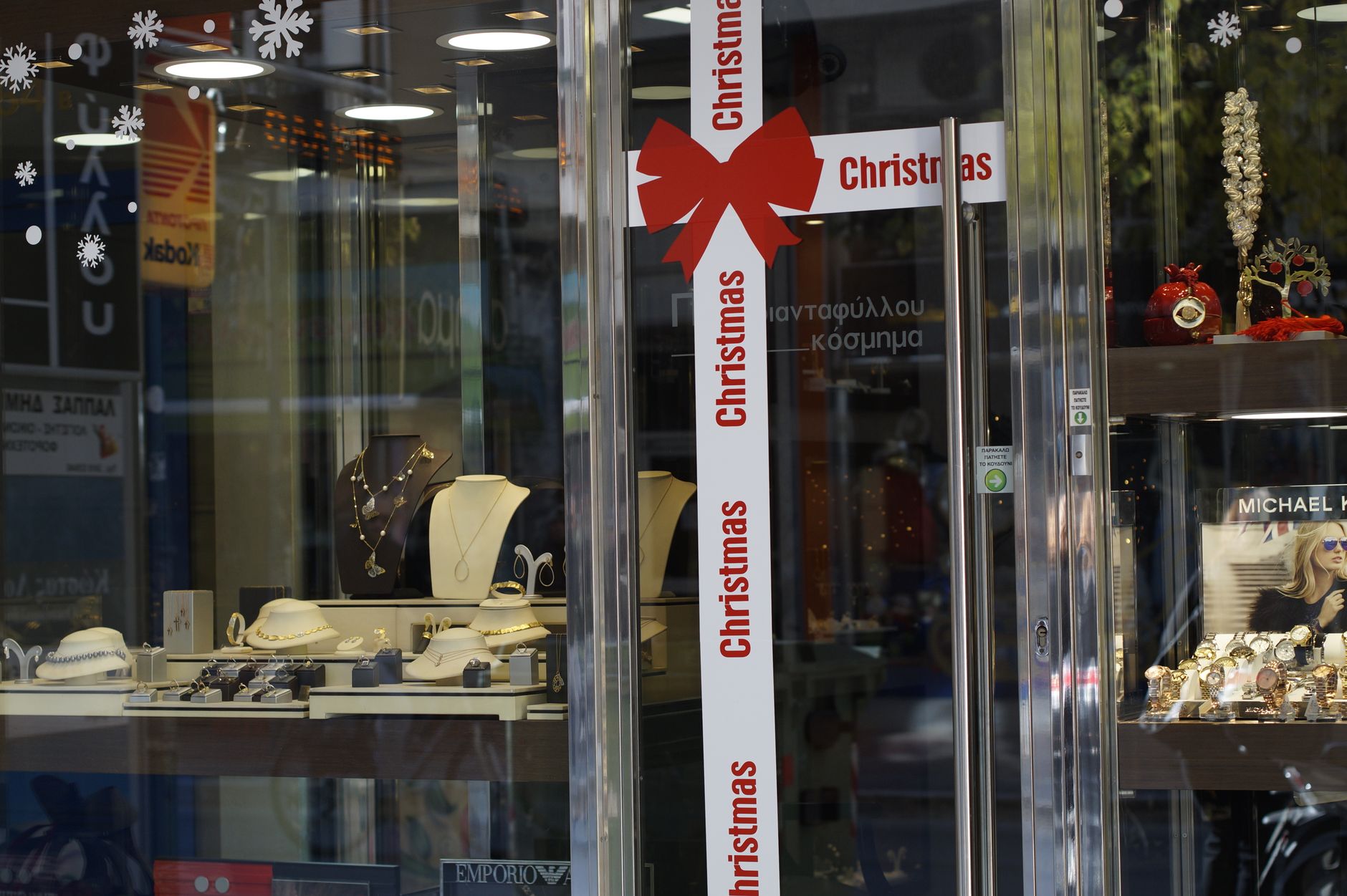 Festive jewelry store window with holiday decorations and elegant jewelry selection.