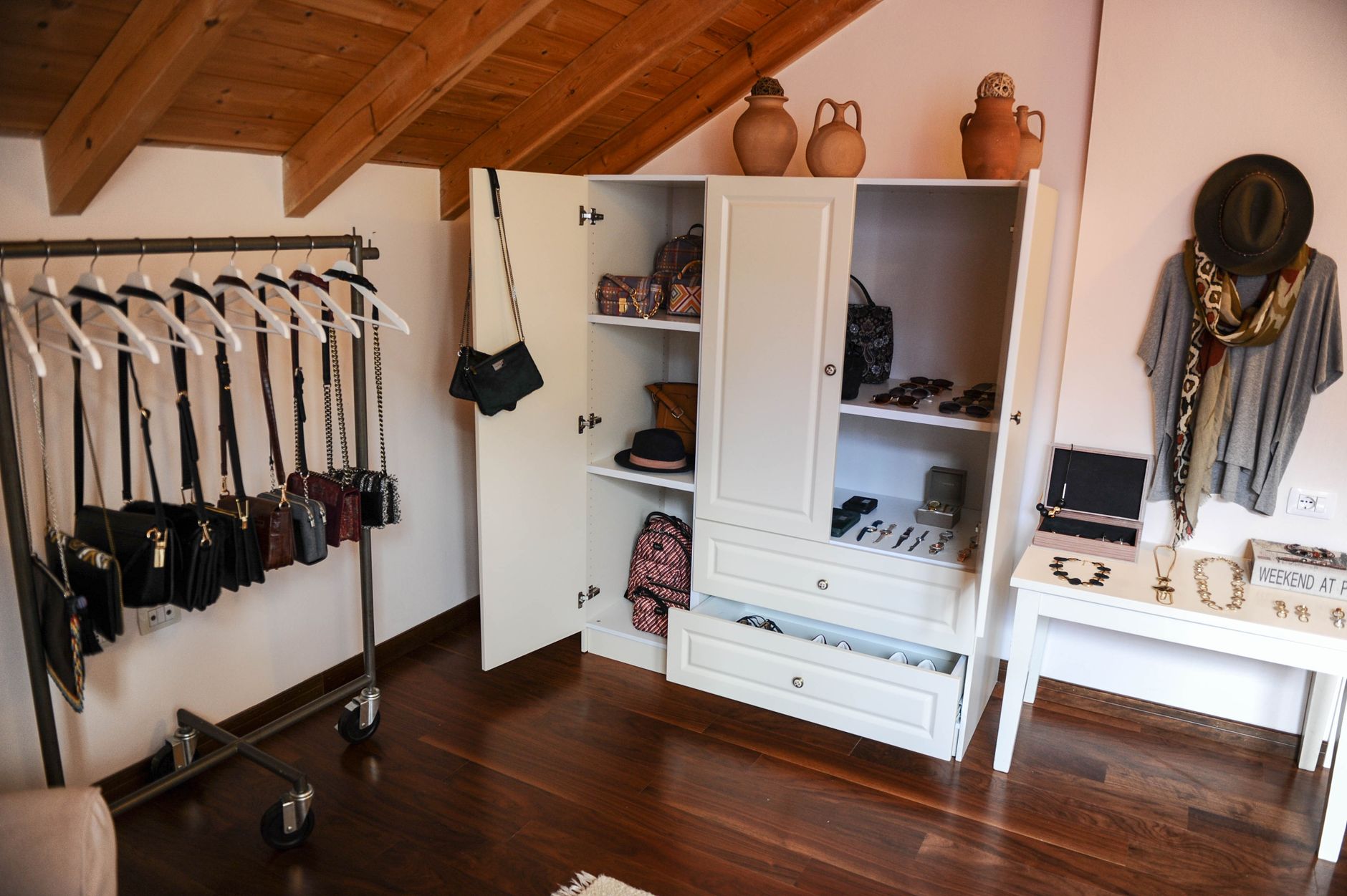 Interior of a modern walk-in closet featuring a variety of accessories and fashion items on display.