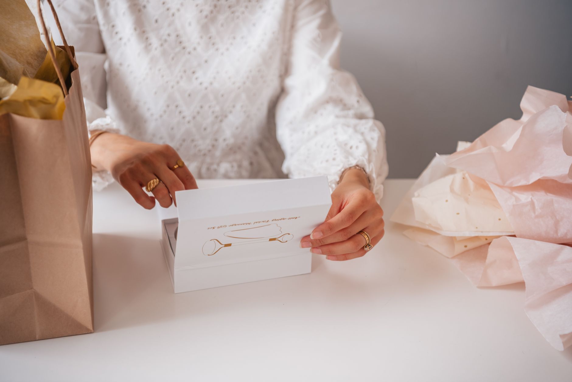 Woman with rings opening a jewelry gift box, emphasizing elegance and anticipation.