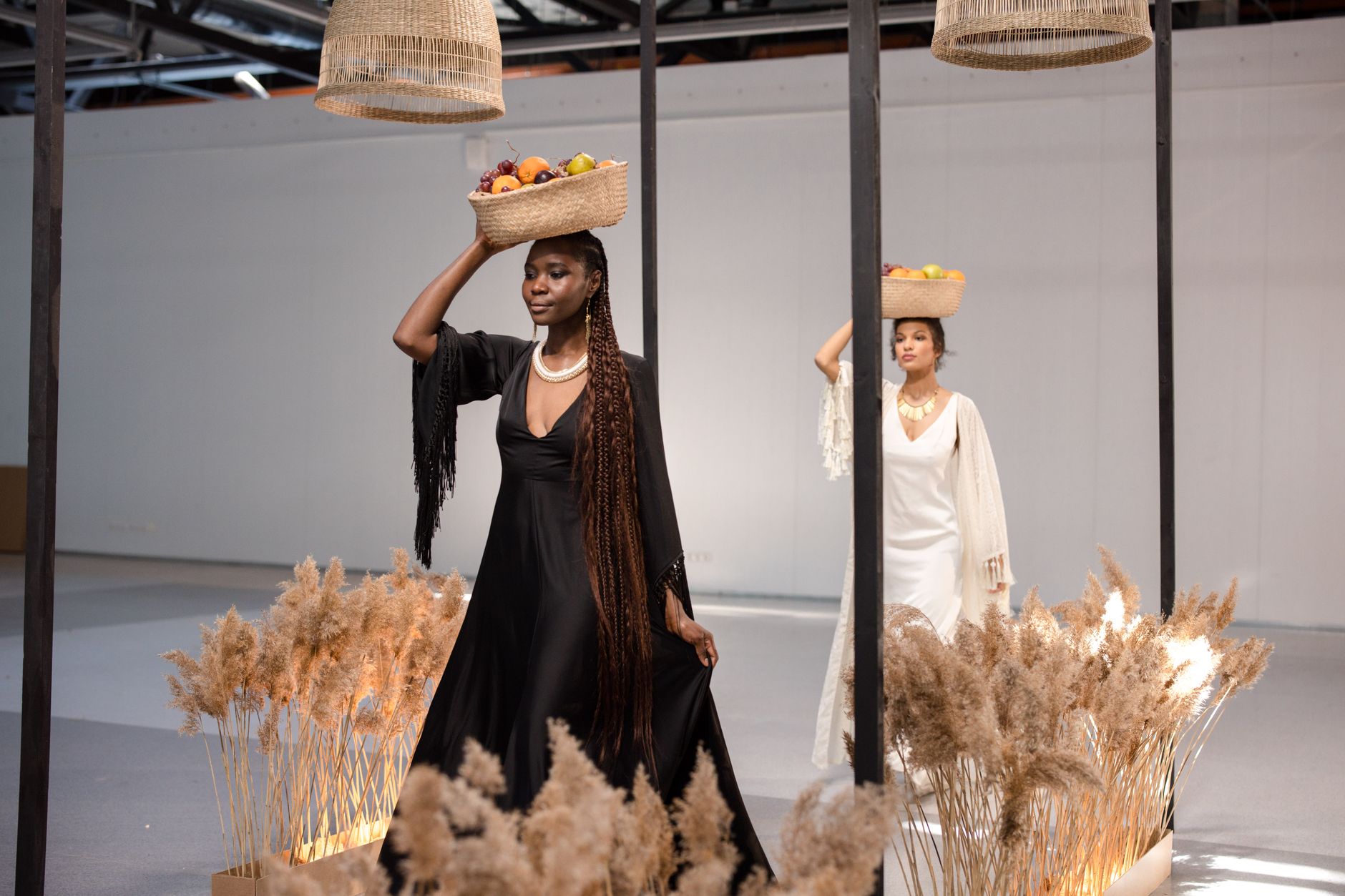 Elegant models in fashionable attire display fruit baskets on their heads, creating a sophisticated and artistic visual.