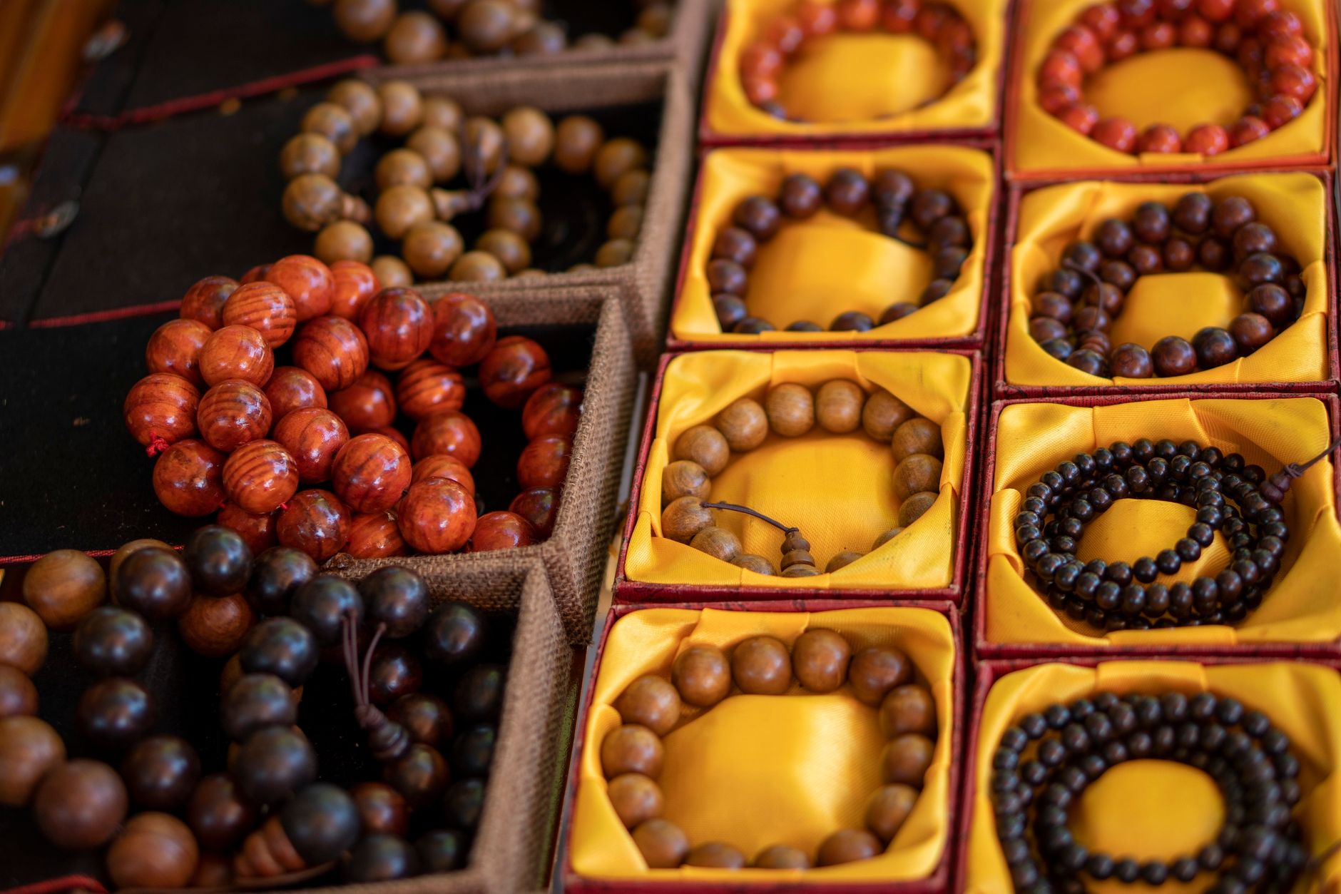 Close-up of colorful wooden bead bracelets in decorative boxes.