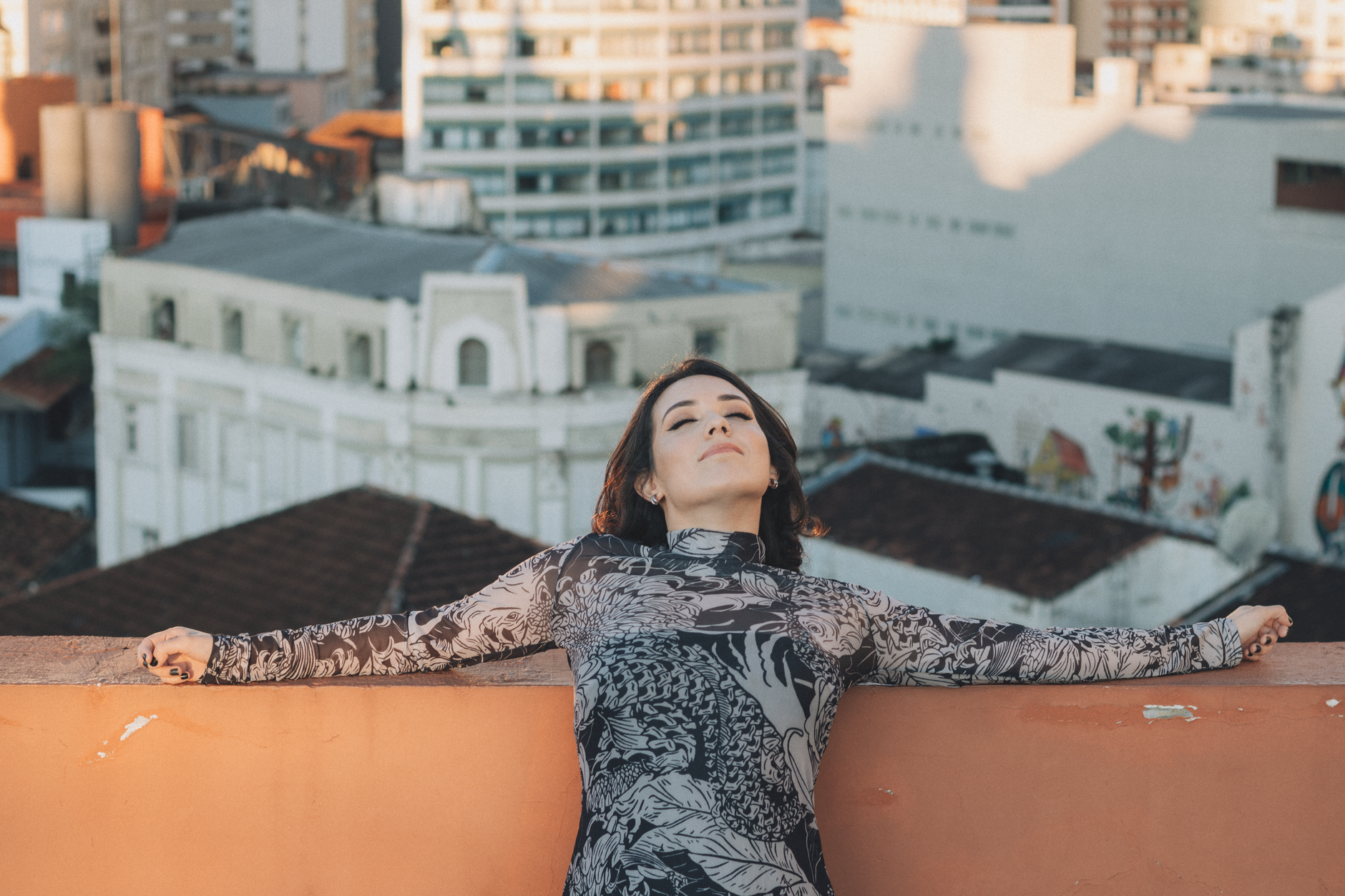Woman relaxing on a rooftop in the city, enjoying a sunny day. Urban tranquility amidst skyscrapers.