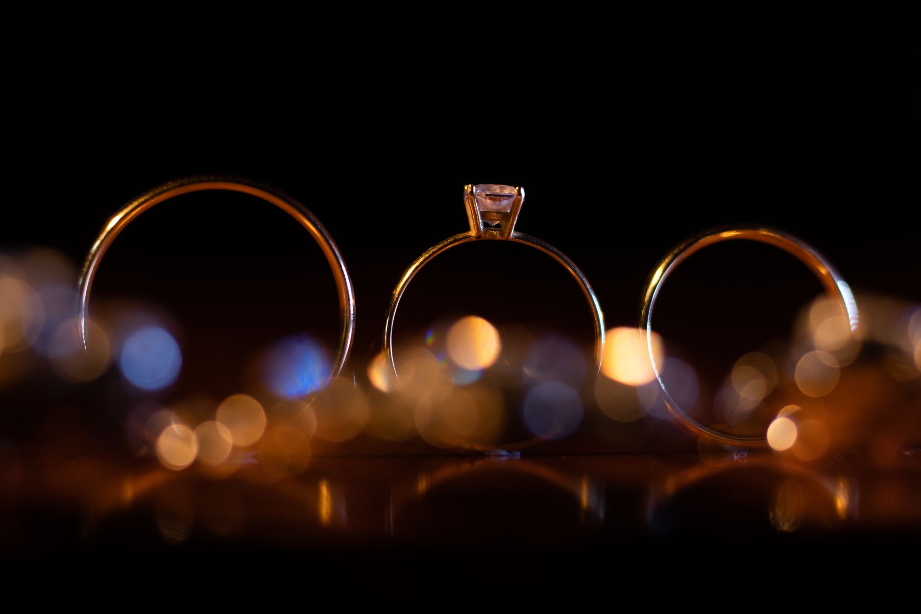 Artistic close-up of gold wedding rings with soft bokeh, symbolizing luxury and commitment.