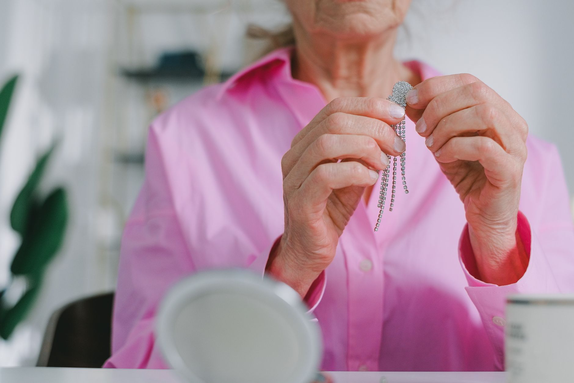 Senior woman holds sparkling jewelry, highlighting elegance in daily life.