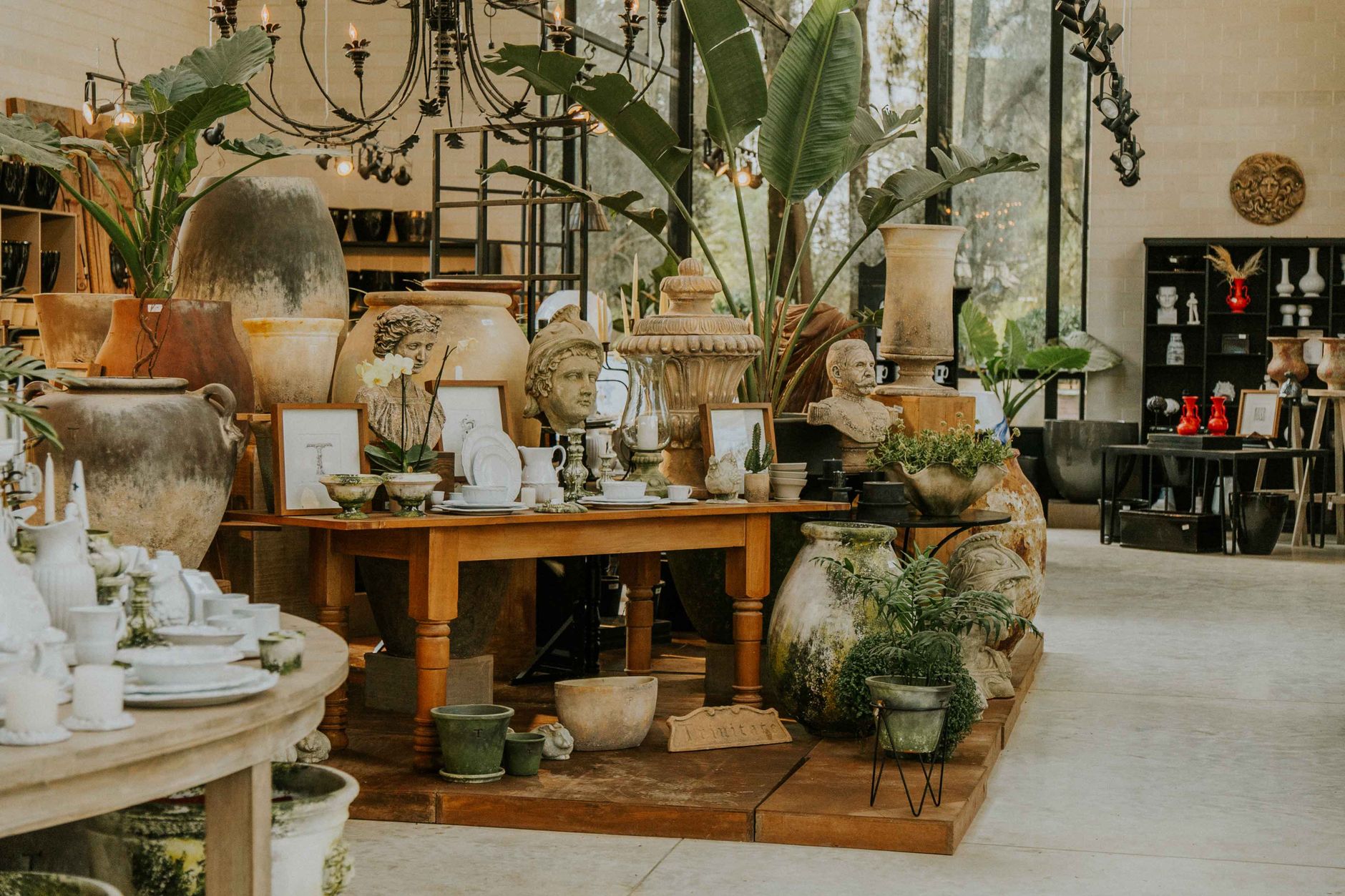 Charming interior of a pottery shop with decorative vases, figurines, and plants.