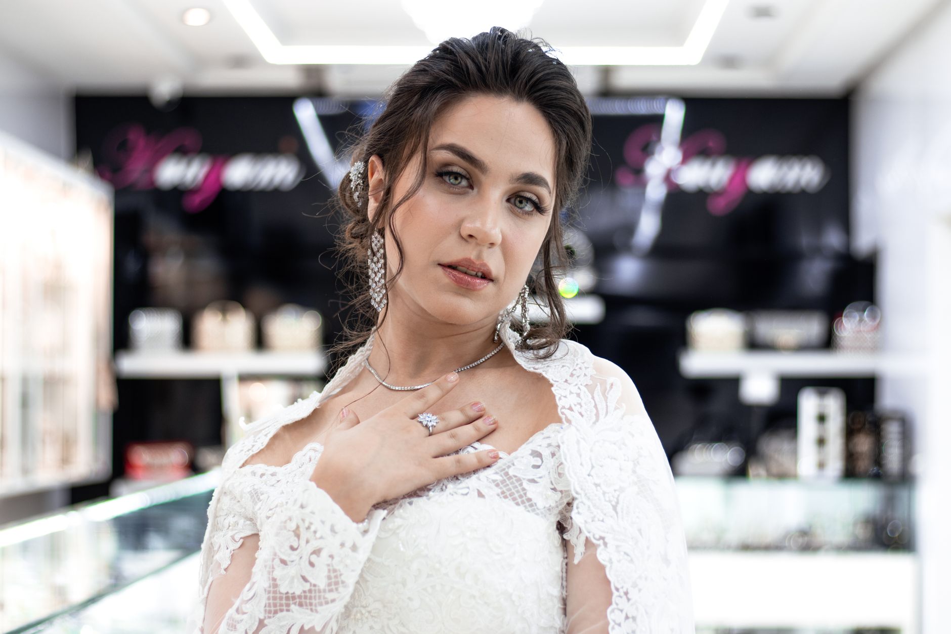 Stunning bride in a white wedding dress with glamorous details captured in an elegant jewelry store.