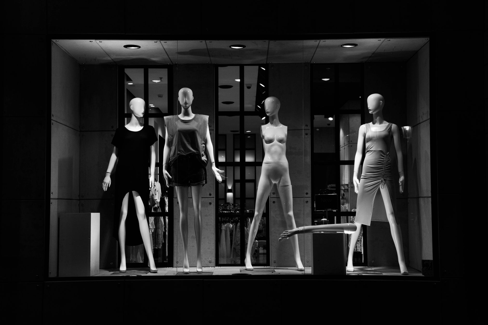 Elegant fashion mannequins showcased in a monochrome boutique window display.