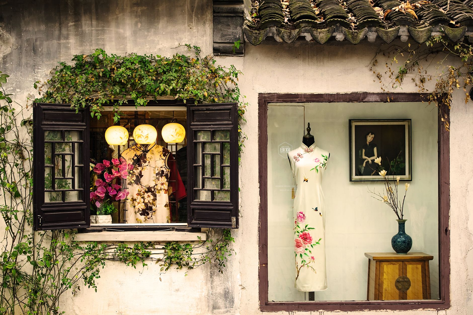 Beautiful display of traditional Chinese dresses in a quaint vintage shop window.