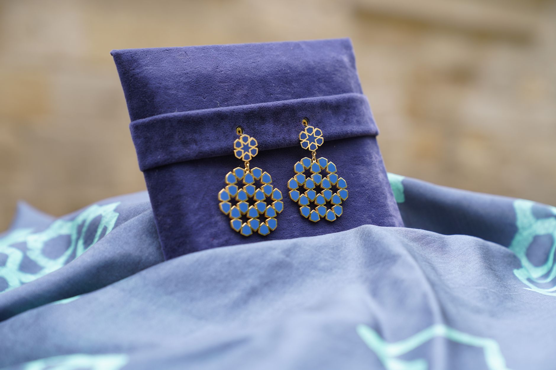 Stylish blue earrings displayed on a velvet box, perfect for fashion or jewelry promotions.