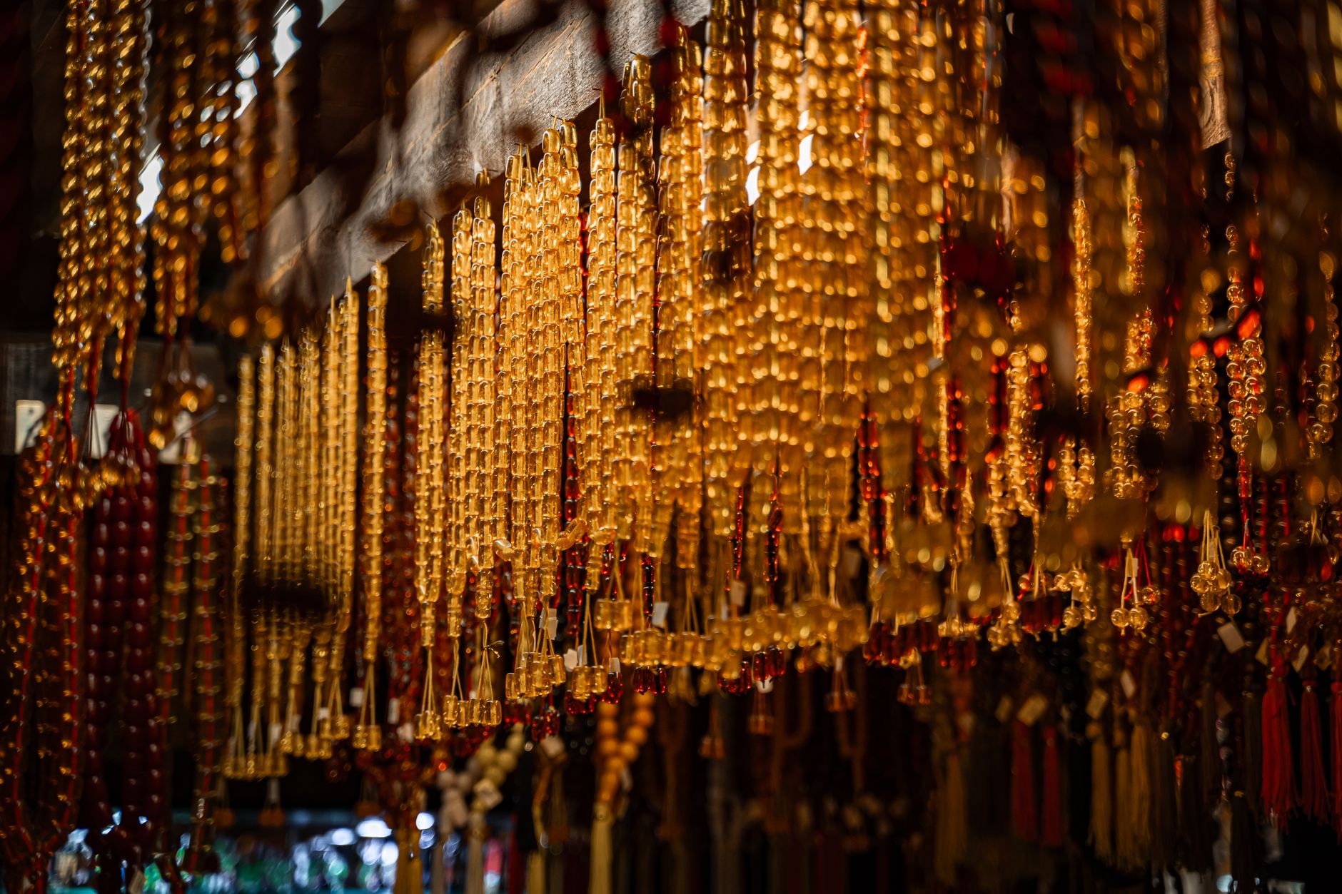 Intricate golden beads hang in a traditional indoor bazaar, creating a rich and cultural ambiance.