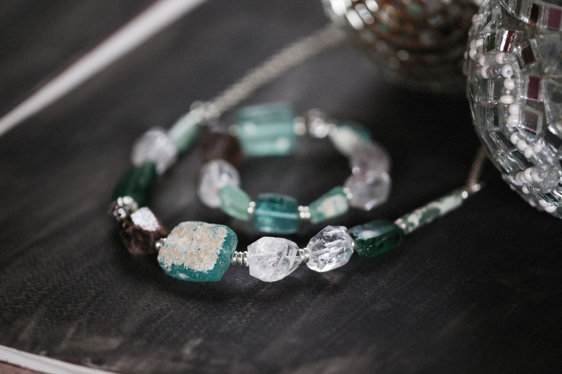 Handmade gemstone bracelet with rough stones shimmering in a stylish, artistic setup.