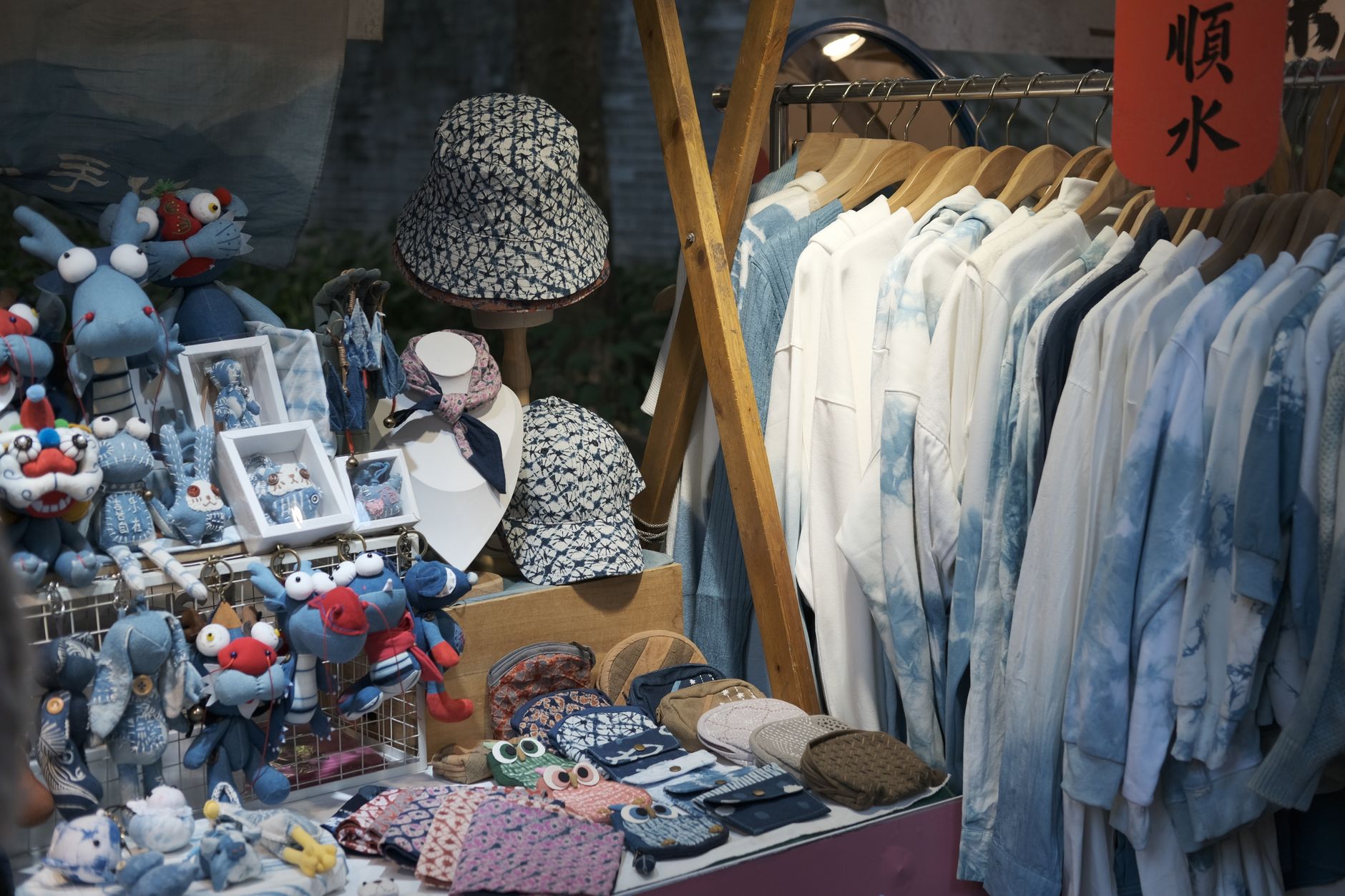 A vibrant stall featuring handmade crafts and clothing displayed neatly.