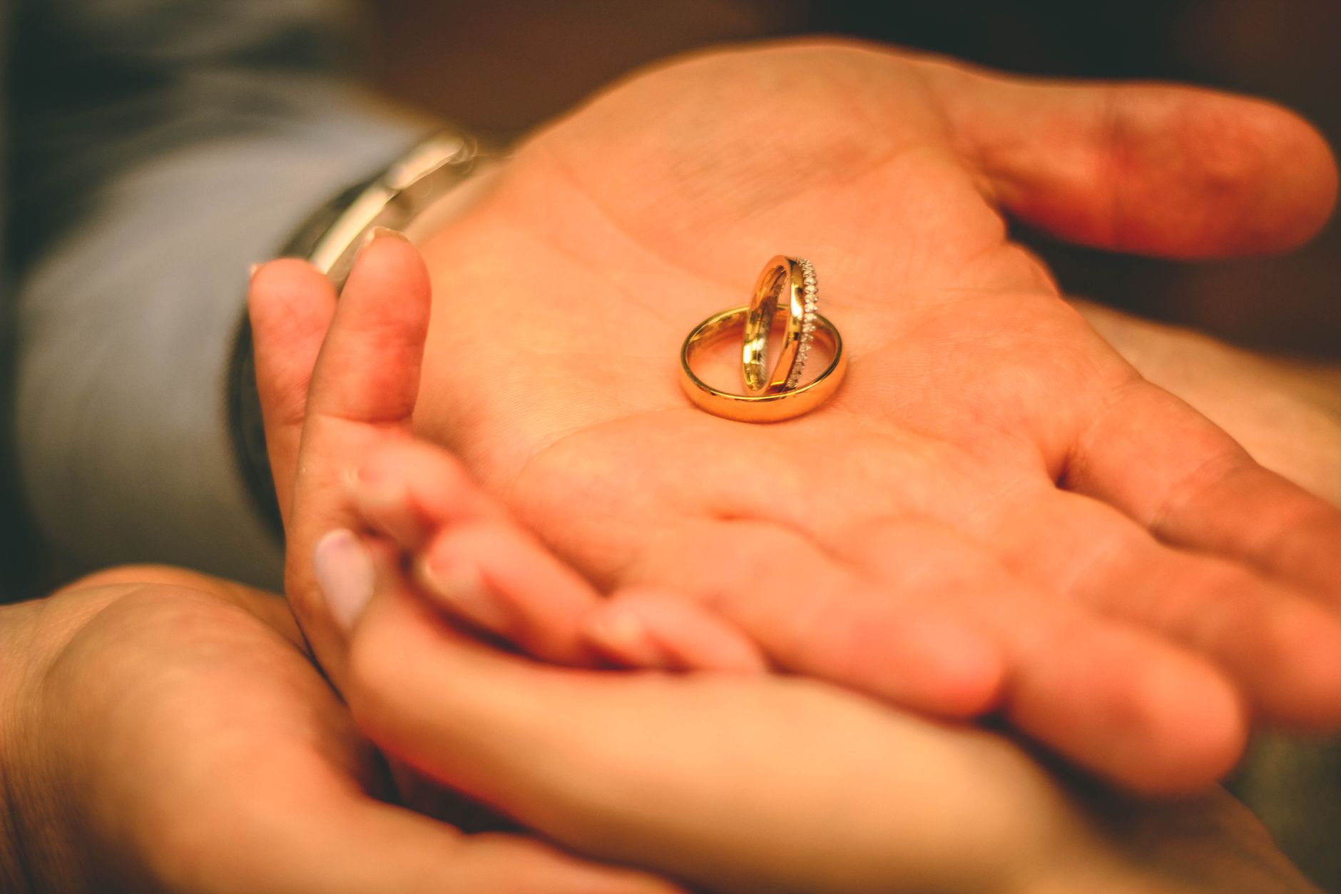 A close-up shot of wedding rings held in the palms, conveying love and commitment.