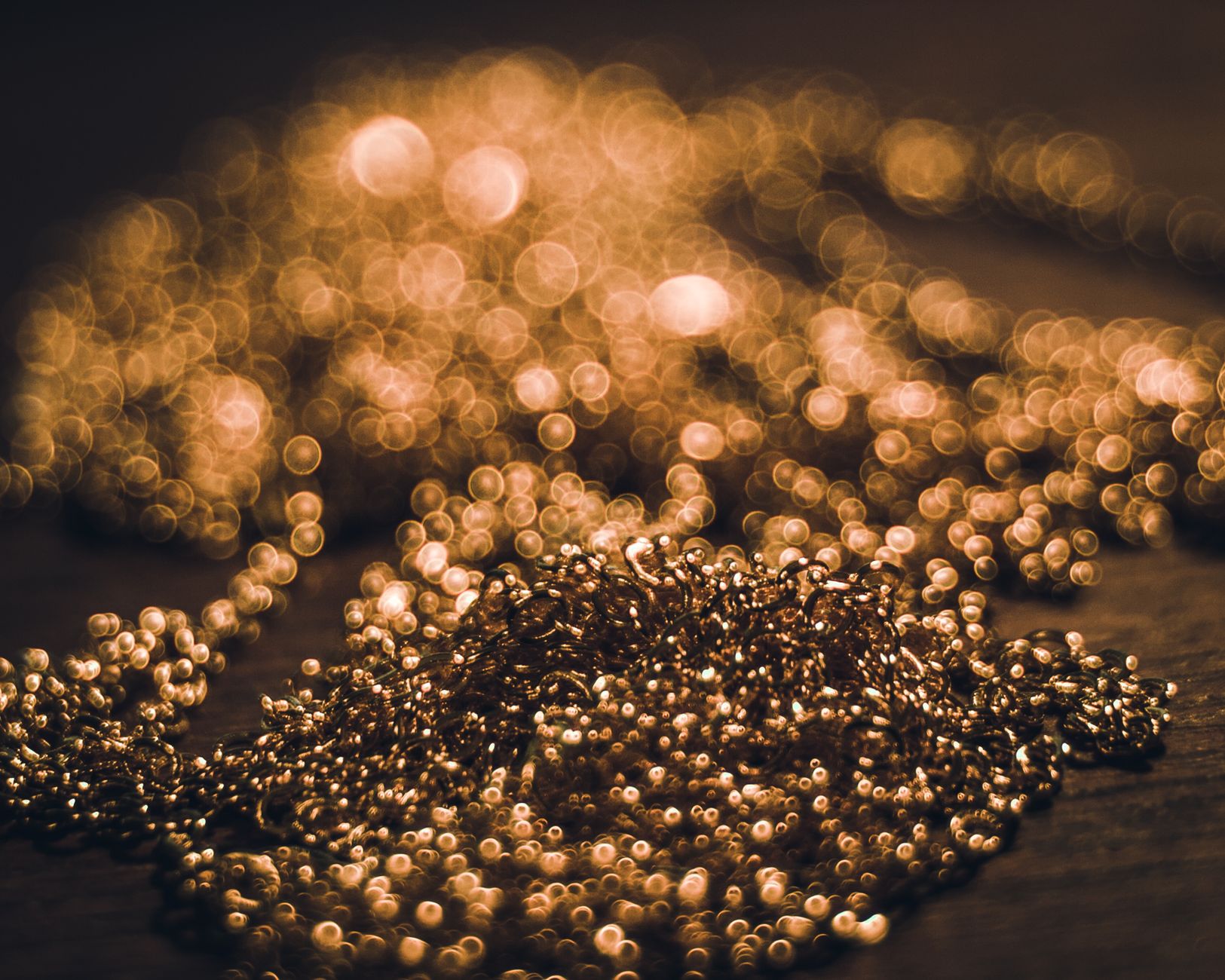 Abstract close-up of golden beads with a stunning bokeh effect, showcasing shimmering lights.