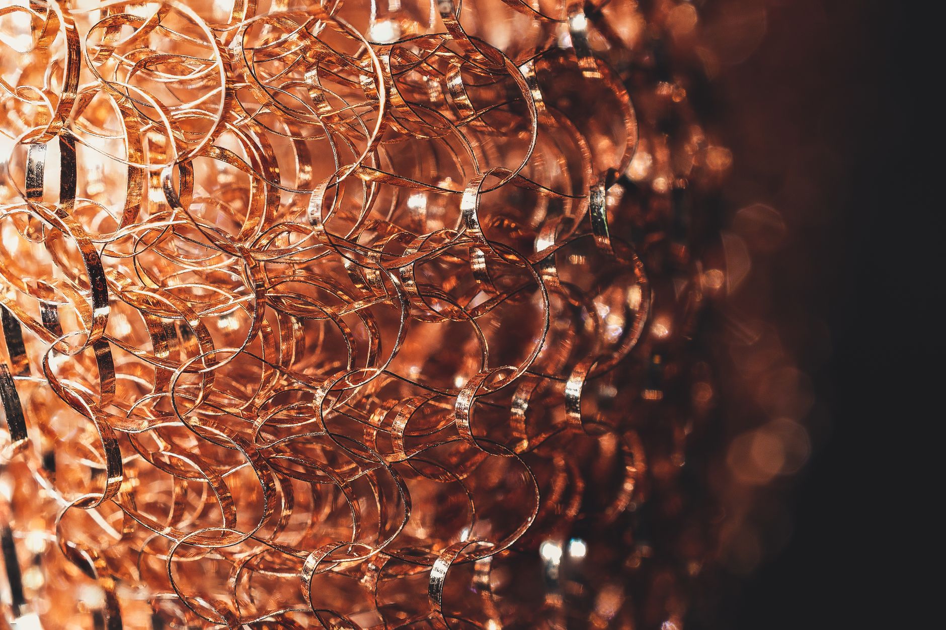 Closeup of textured backdrop with thin brown wavy wire with glowing surface on black background