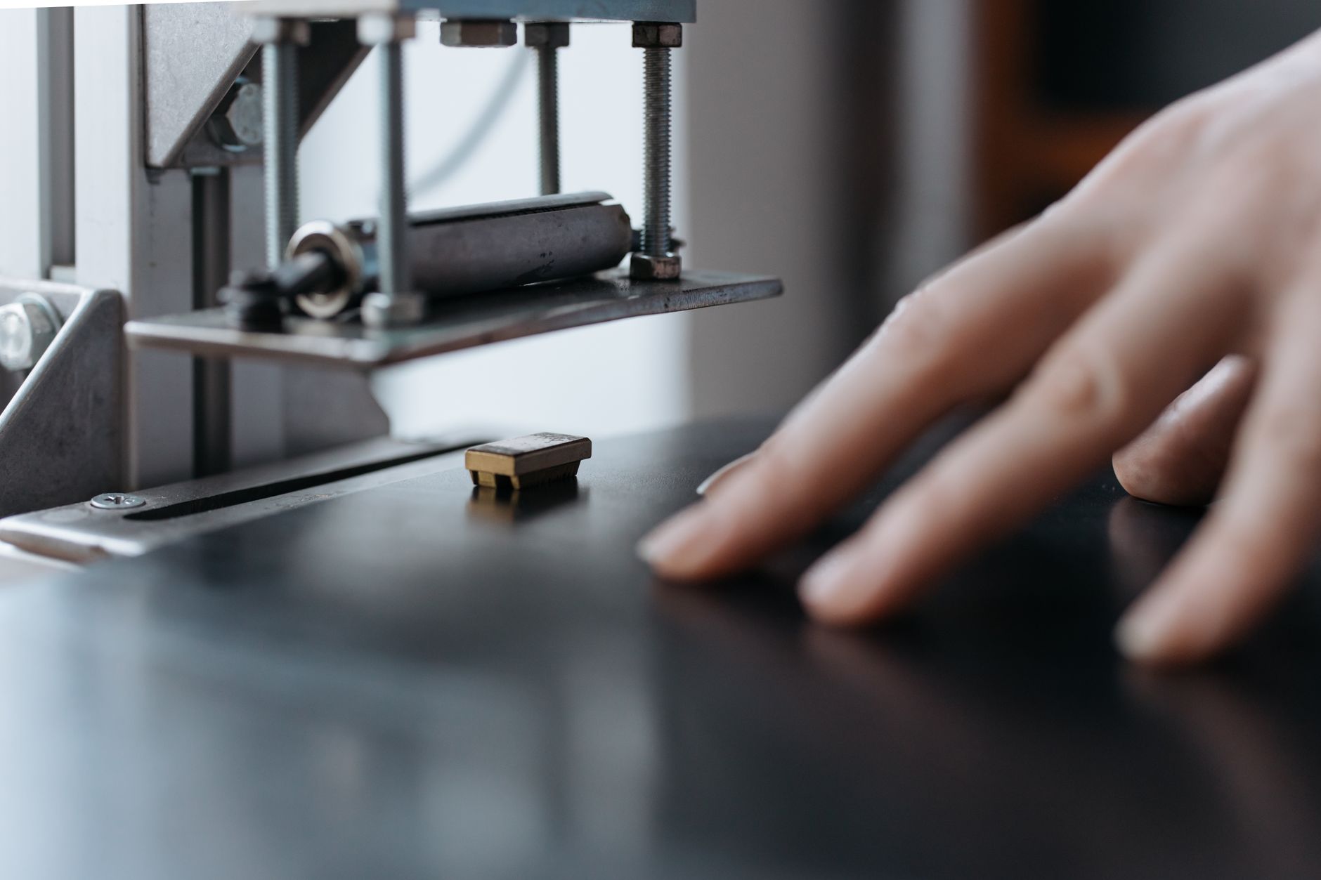 A hand operating an industrial machine, focusing on the delicate touch and intricate machinery.