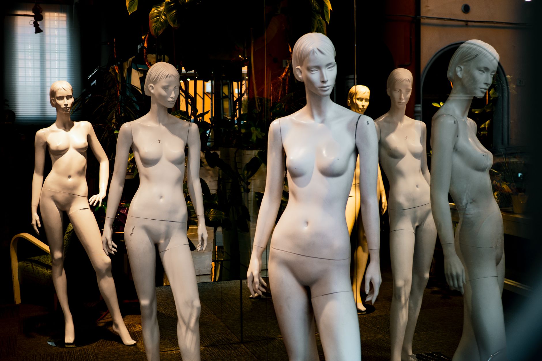 A captivating storefront display featuring multiple mannequins in artistic arrangements.