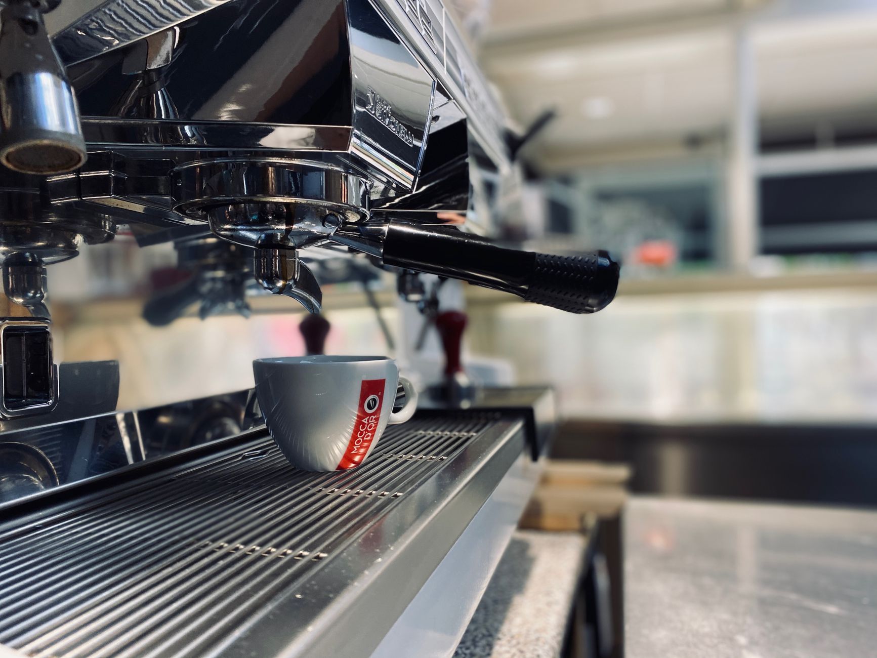 Close-up view of an espresso machine brewing coffee indoors, capturing the sleek design and functionality.