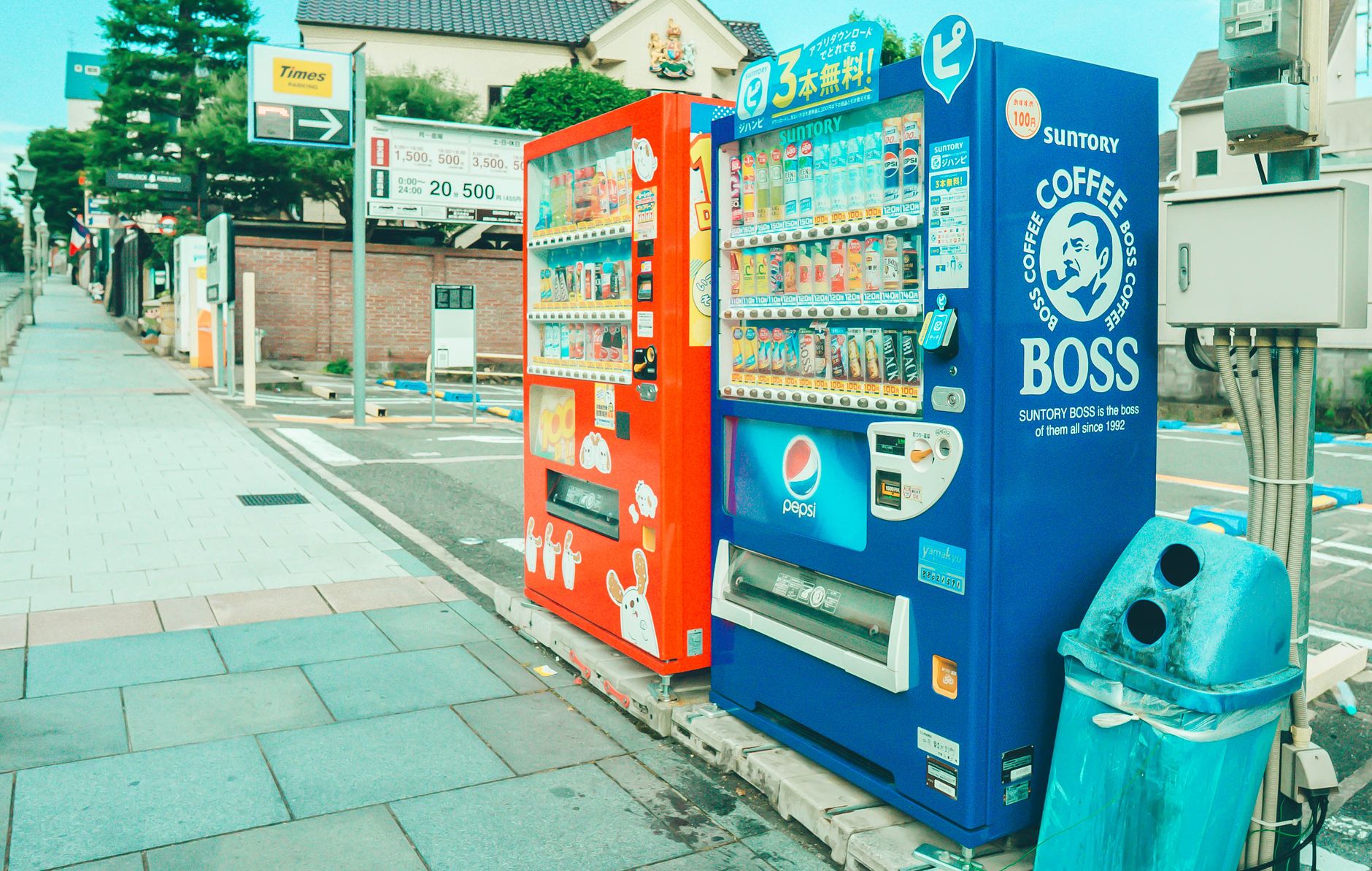 Colorful vending machines offering snacks and drinks on a street in Kobe, Japan.