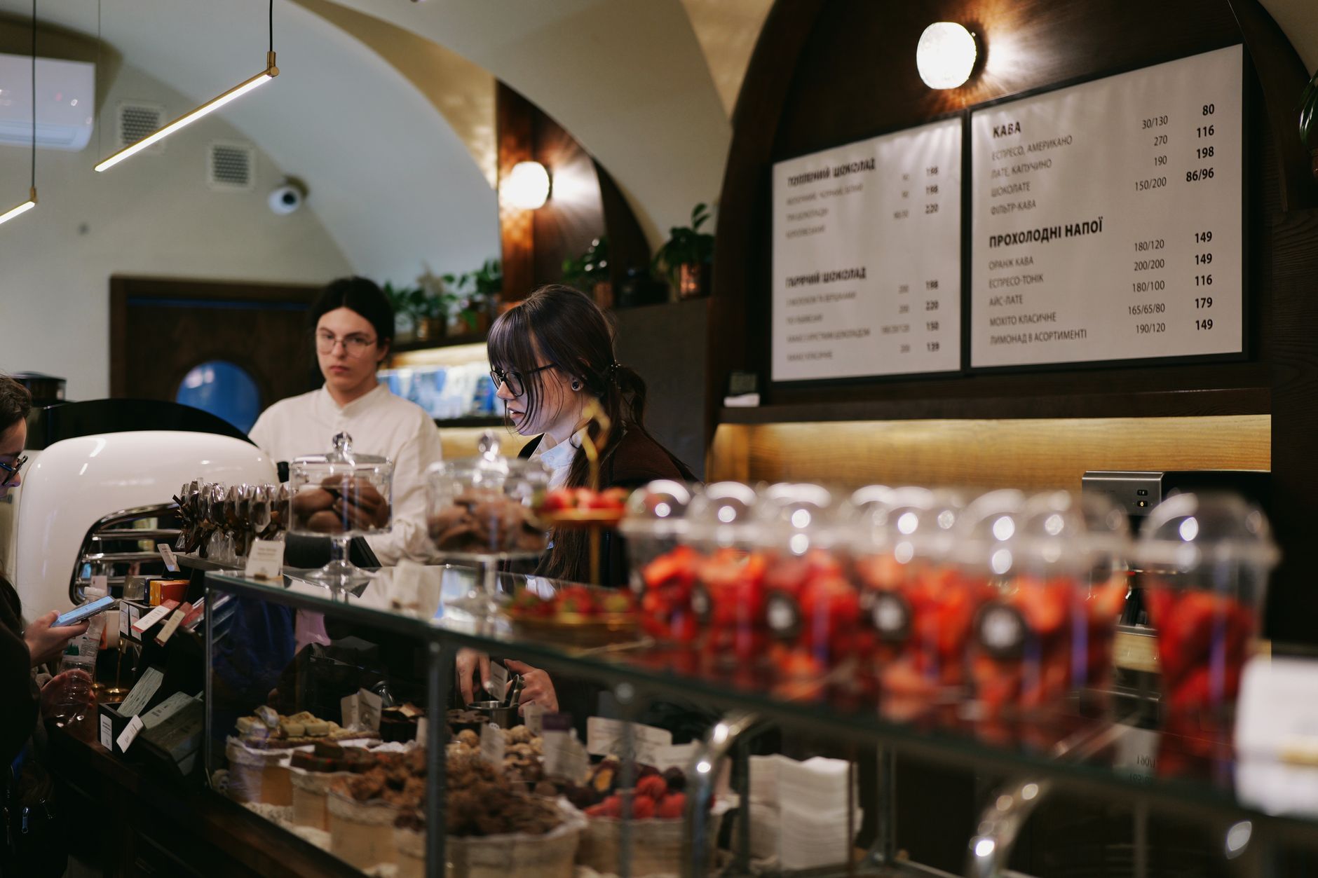Charming cafe scene in Lviv, Ukraine with staff attending to customers at counter.