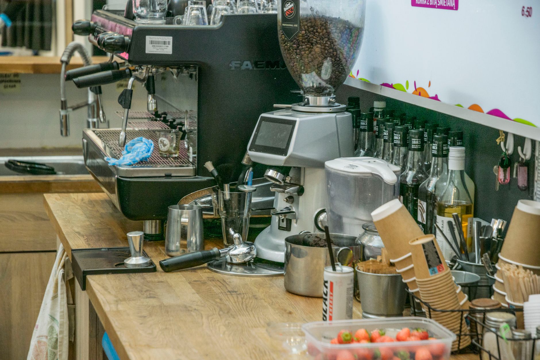 Coffee shop counter with espresso machine and ingredients, ready for brewing.