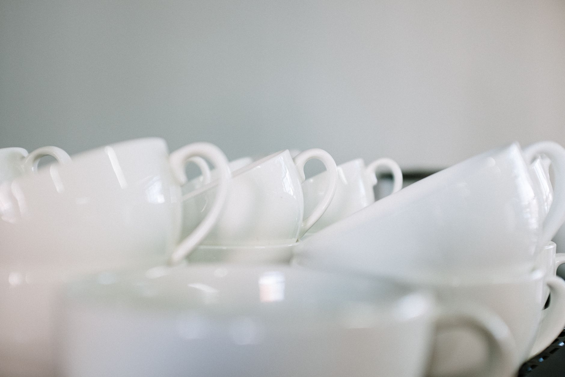 Stacked white coffee cups create a minimalist still life in a café. Perfect for beverage and hospitality themes.
