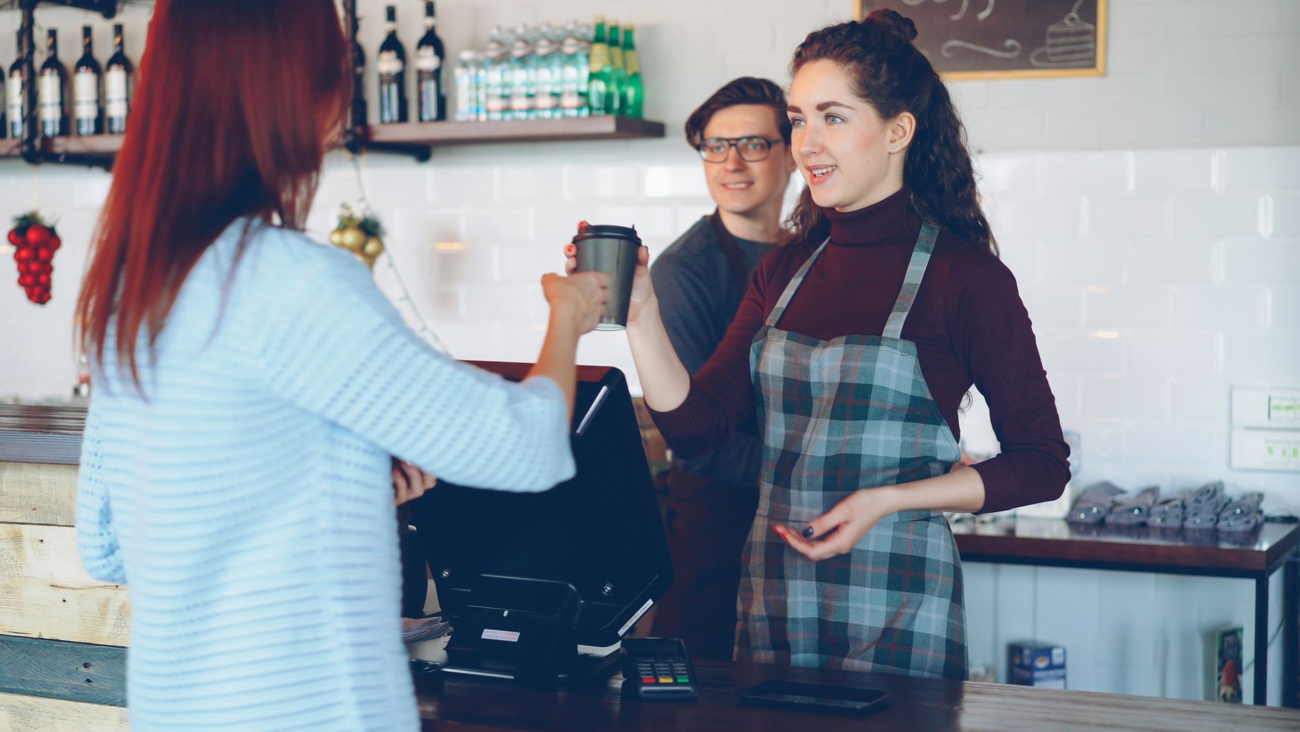 Barista serving coffee to a customer in a cozy café setting, fostering warm interpersonal interactions.