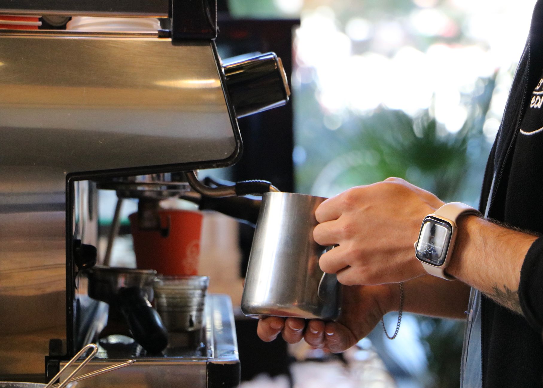 Barista steaming milk at a café in İstanbul, showcasing coffee culture.