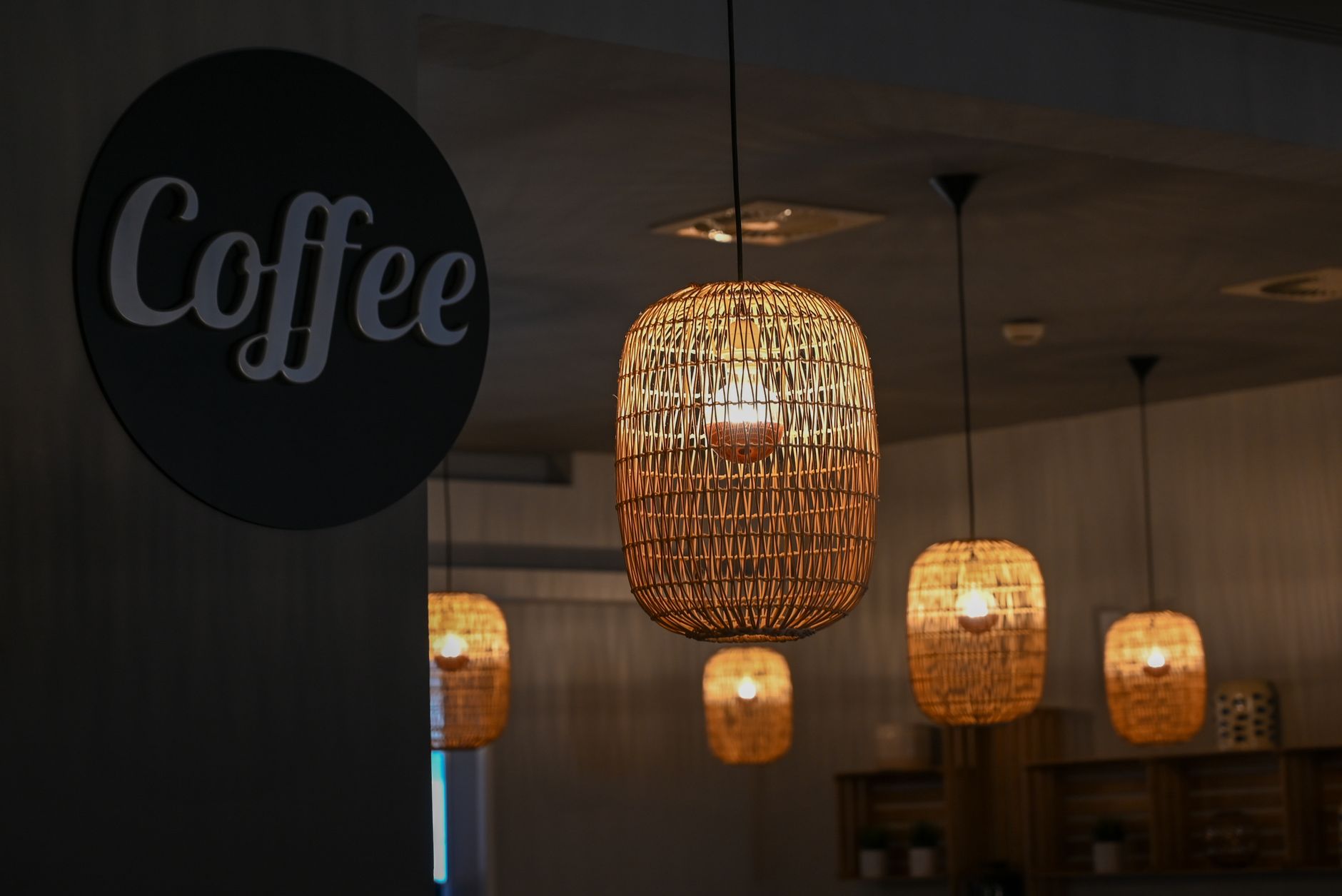 Warm and cozy café interior with woven wicker lamps creating an inviting ambiance.