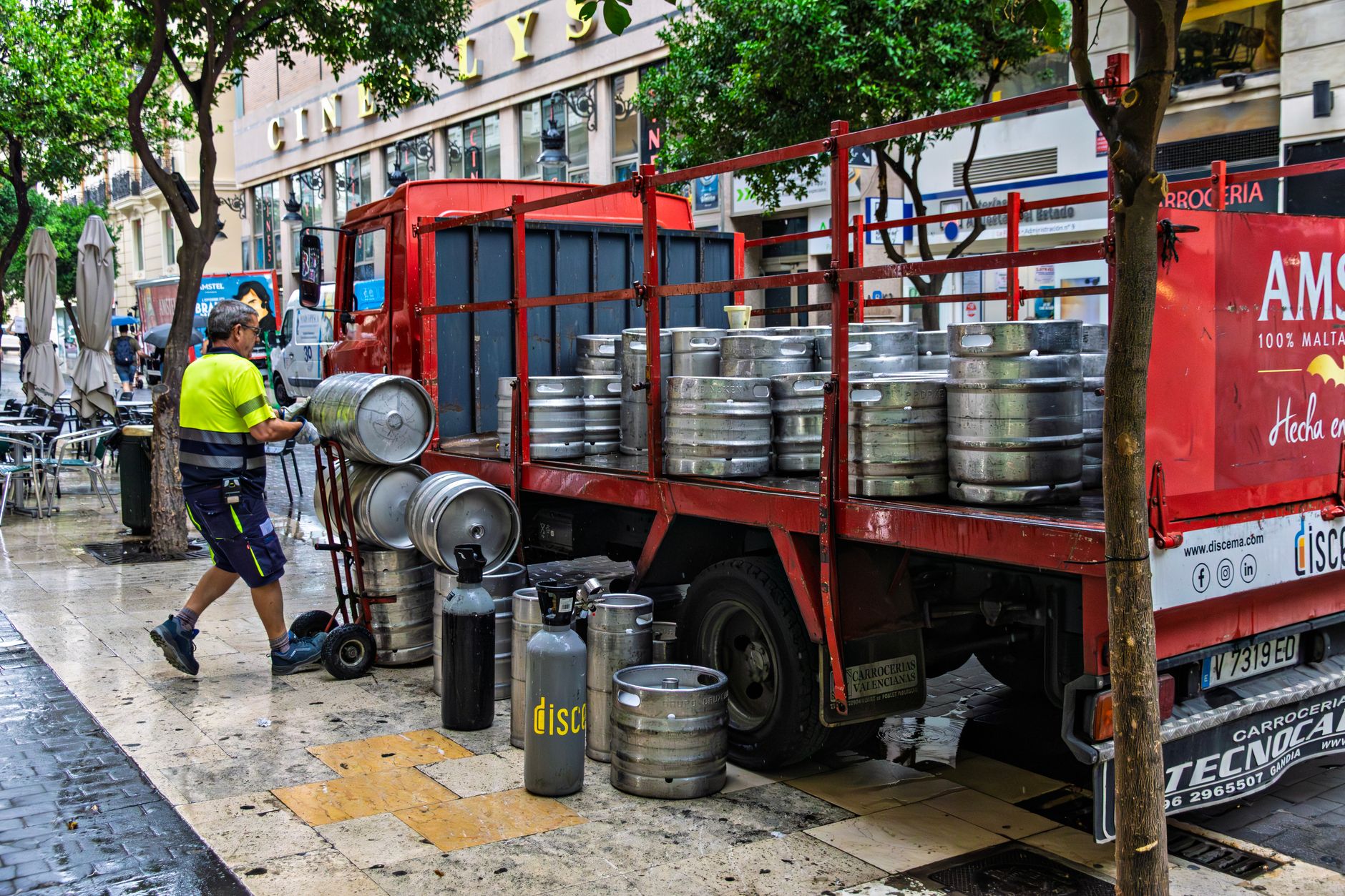 Man unloading beer kegs from a truck in Valencia, Spain.