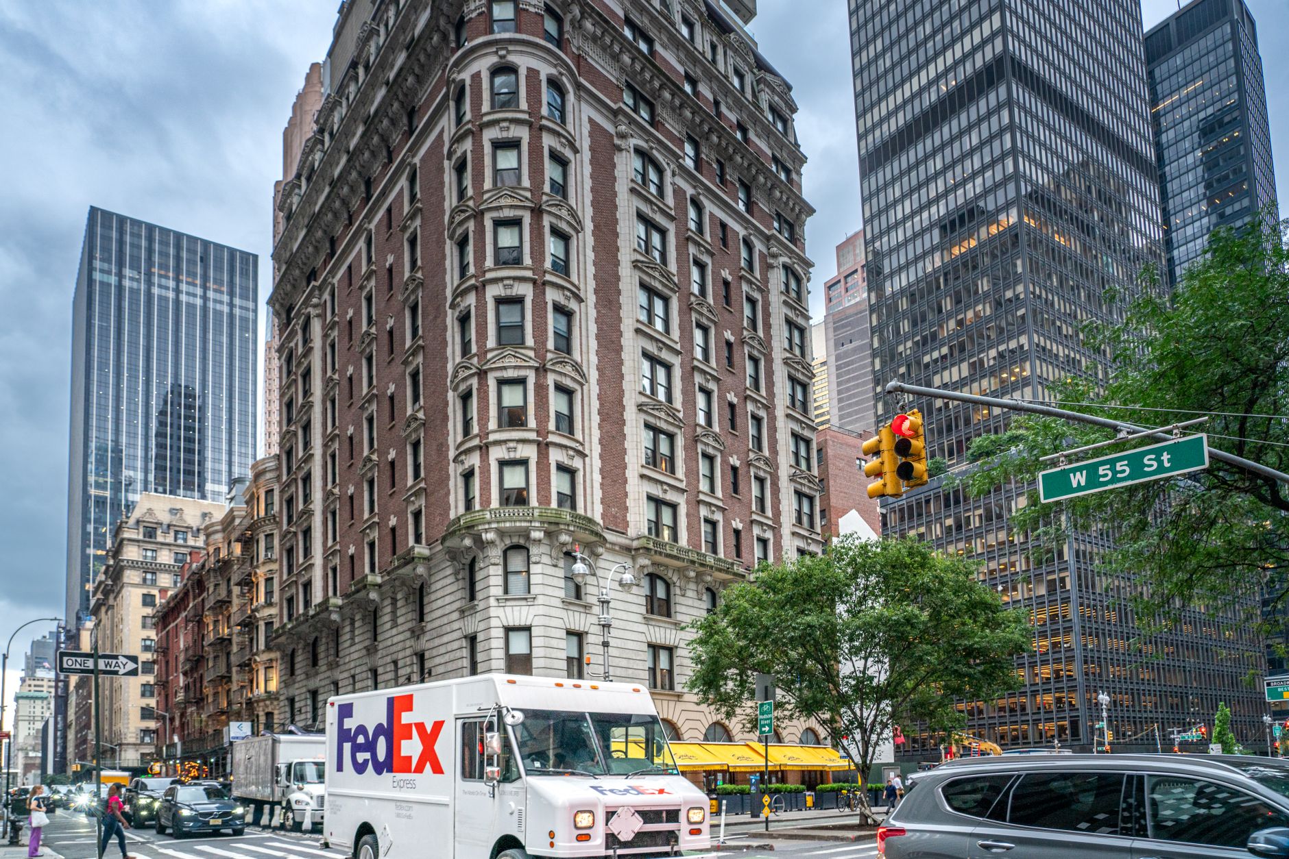 FedEx truck on a bustling street in New York City with skyscrapers and traffic, showcasing urban life.