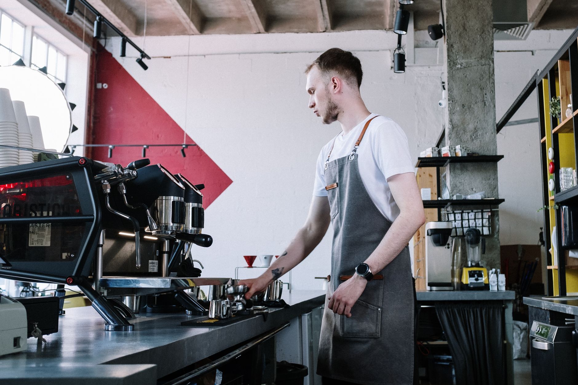 A skilled barista operates an espresso machine in a trendy coffee shop setting, creating a perfect brew.