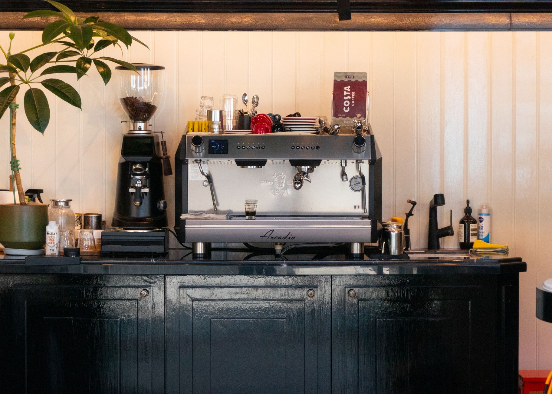 A charming coffee shop interior featuring a modern espresso machine and coffee grinder, evoking a warm, inviting atmosphere.