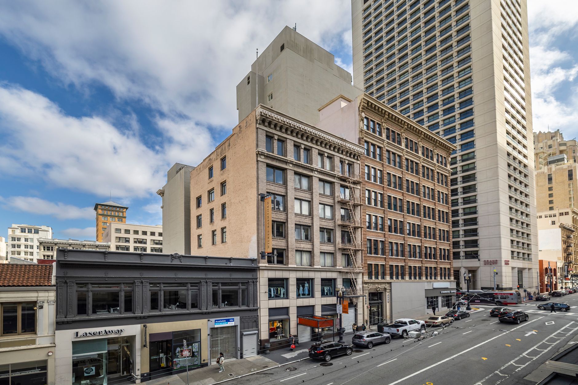 Morning view of a bustling urban street with historic and modern architecture, capturing city life.