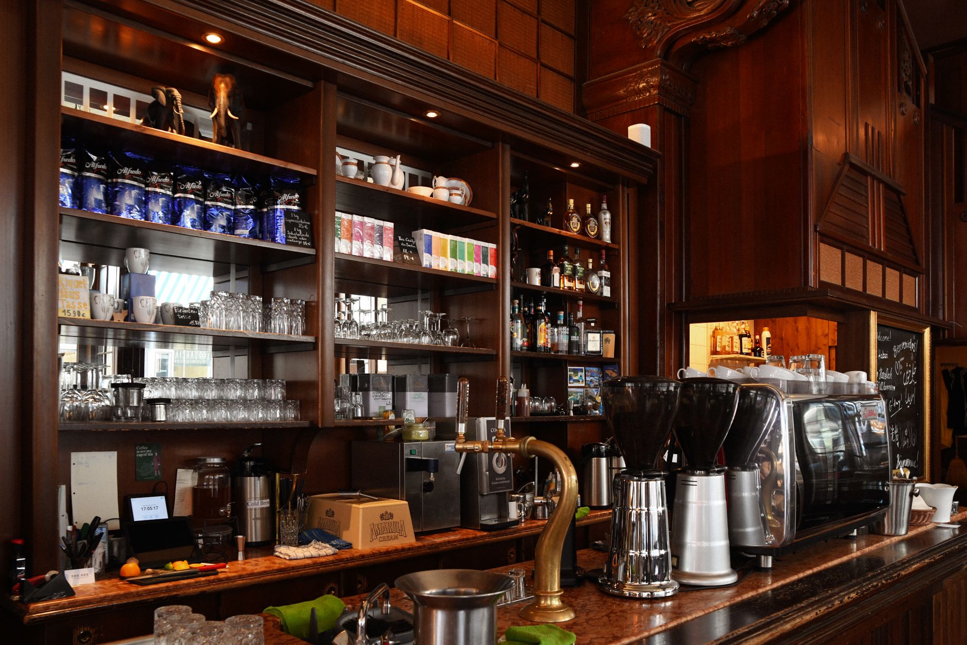 Elegant coffee shop counter displaying an espresso machine and various drinks.