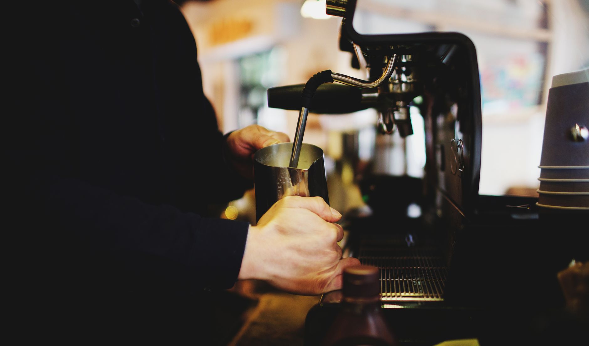 Close-up of a barista using an espresso machine in a cozy cafe.